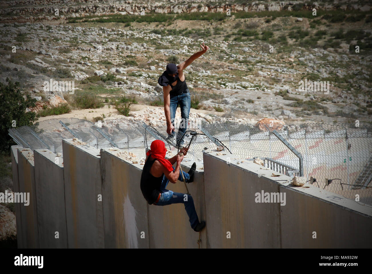 Palestinian youth activists disable motion sensors on Israel's separation wall. West Bank. Stock Photo