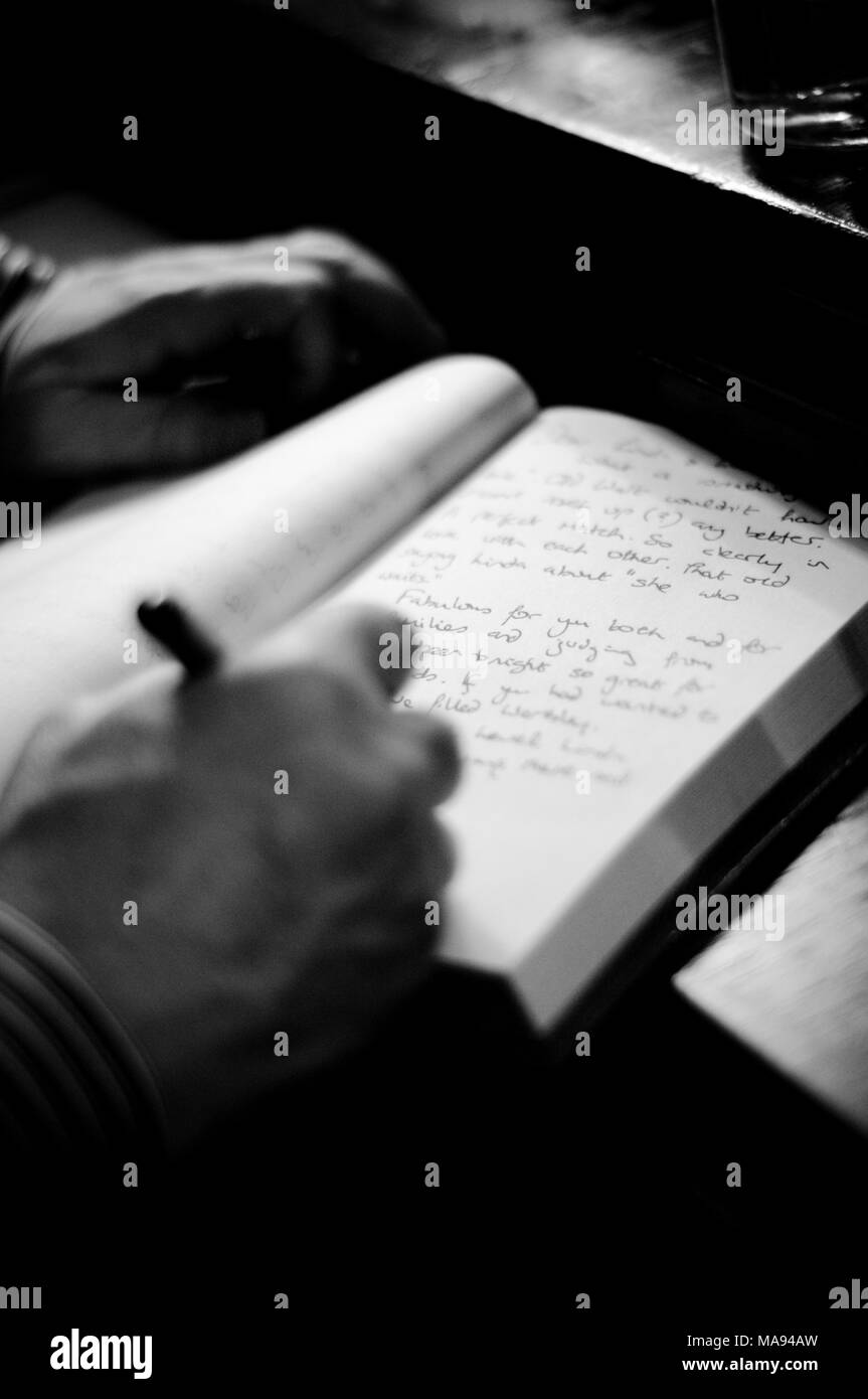 A man signs a comments book at a wedding Stock Photo