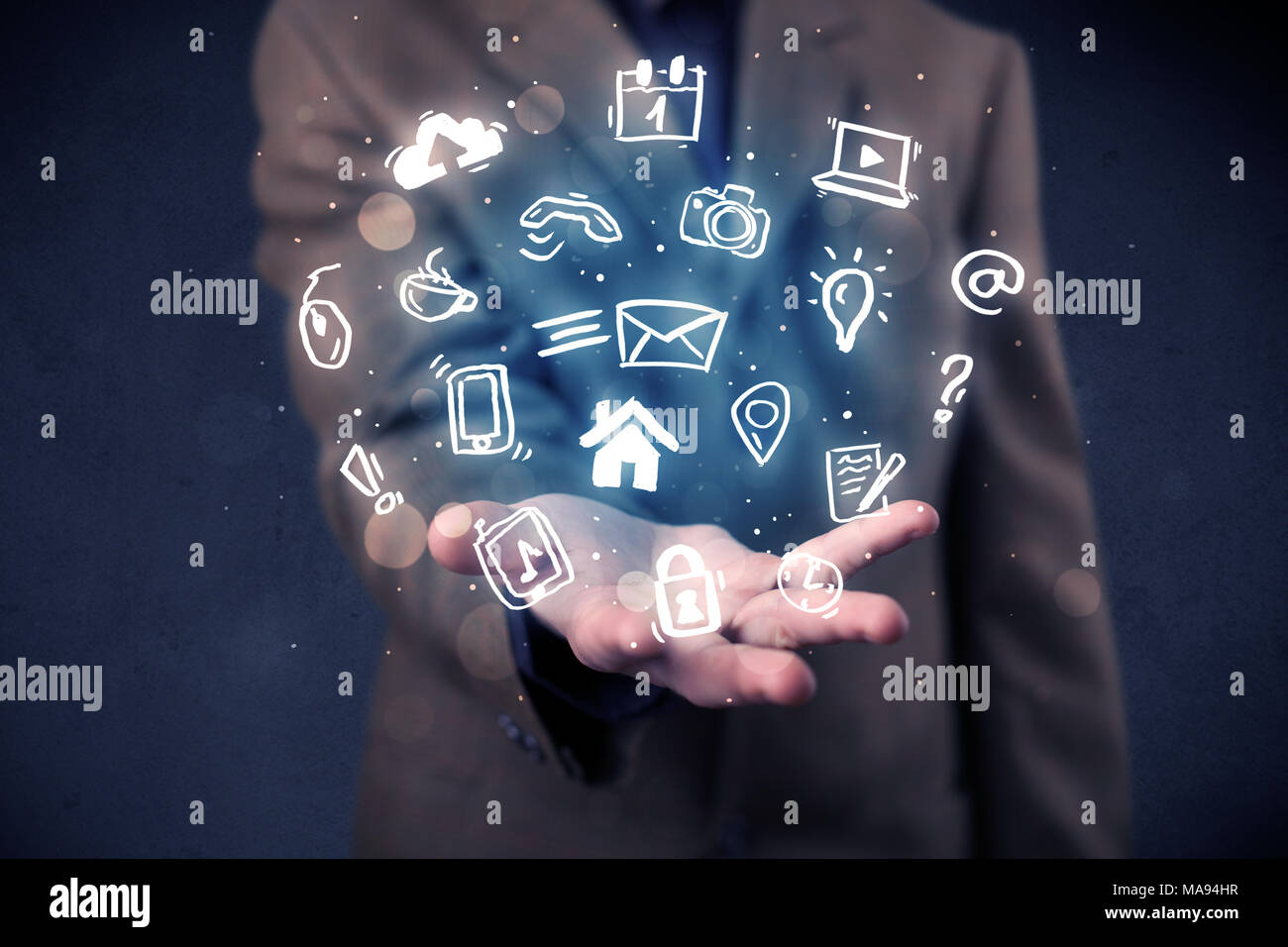 Blue multimedia icons in the hands of a businessman Stock Photo - Alamy