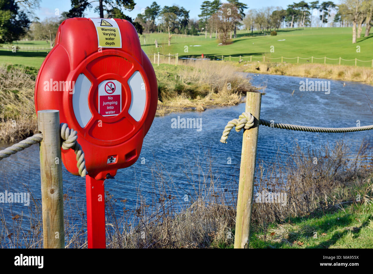 Life saving ring mounted on post by rope fence by river Salwarpe, Droitwich Spa, UK Stock Photo