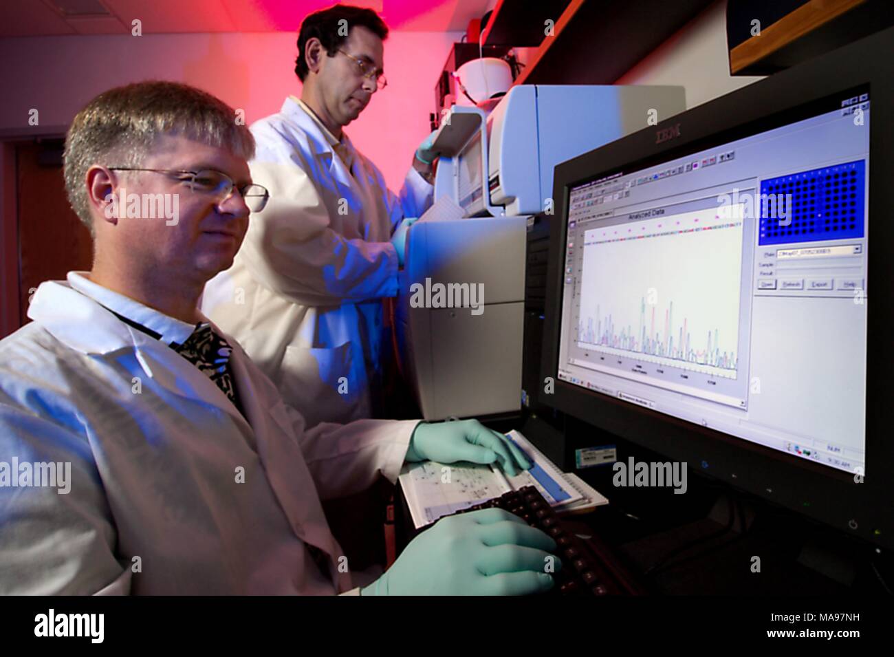 Glenn Morlock and Mitch Yakrus, CDC microbiologists, operating a DNA sequencing instrument, 2007. Image courtesy Centers for Disease Control (CDC) / Hsi Liu, Ph.D. MBA, James Gathany. () Stock Photo