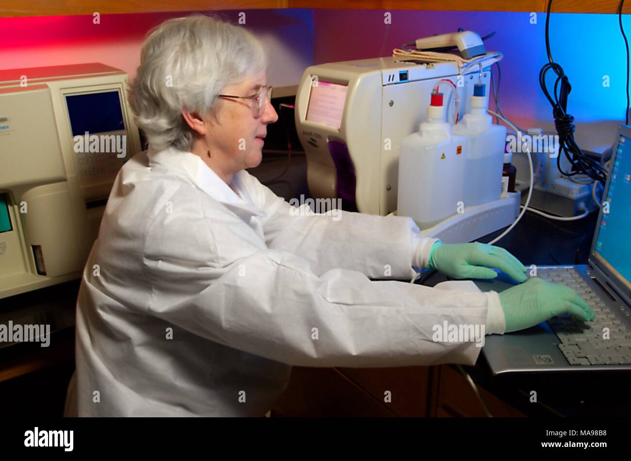 Photograph of Cynthia Warner, a CDC Clinical Monitoring Team member, in a working laboratory setting, next to machines and a computer, testing the effectiveness of anti-retroviral medications on HIV infected blood samples, as part of the Global AIDS program, 2007. Image courtesy CDC/Hsi Liu, James Gathany. () Stock Photo