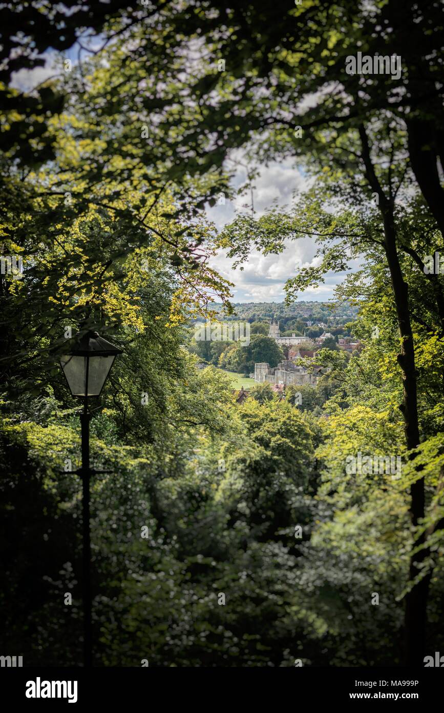 A high view through summer woodland to the distant buildings of St Cross in Winchester, Hampshire, England Stock Photo