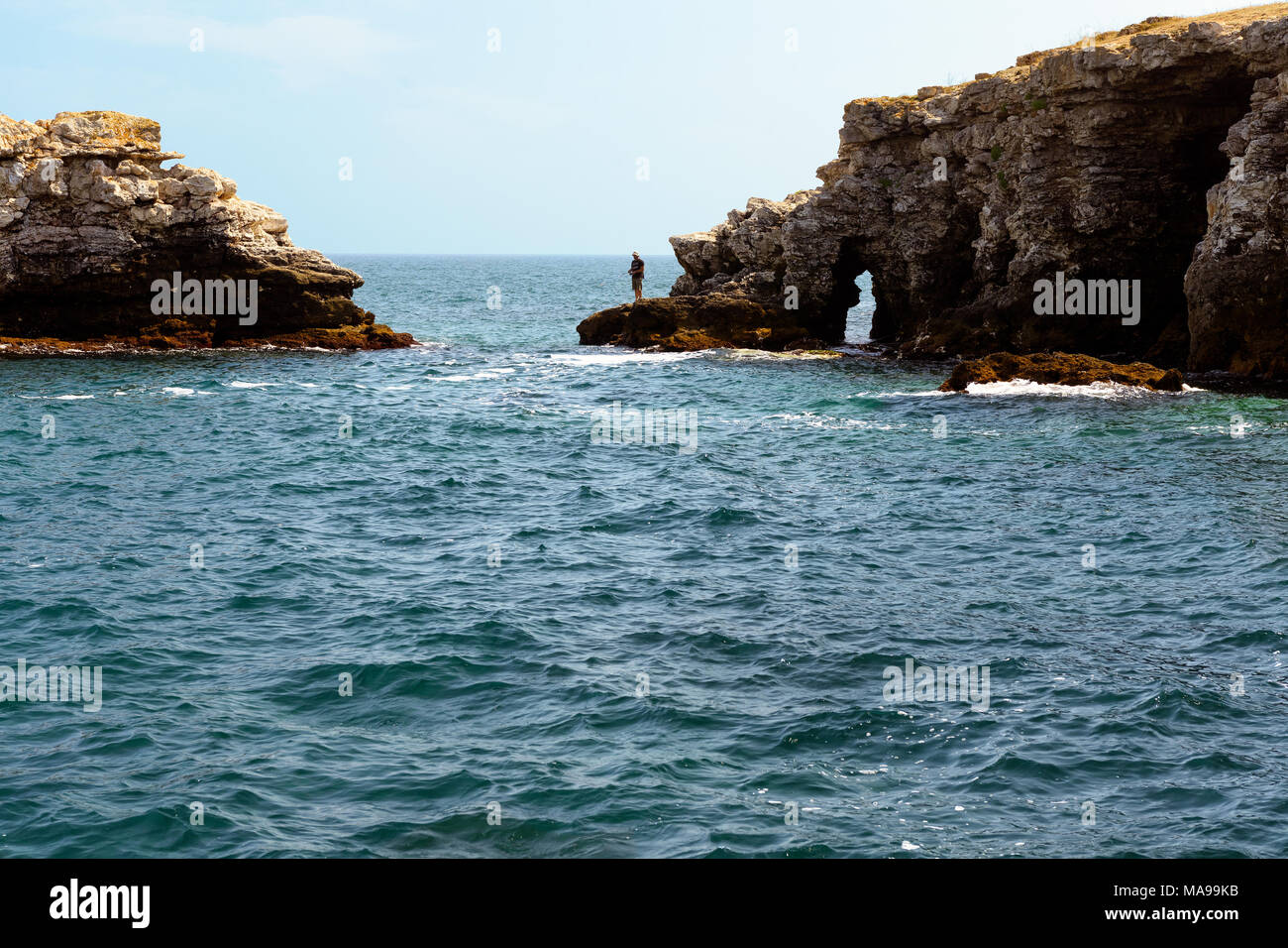 Tyulenovo, Bulgaria - July 20, 2017: Fisherman on the harsh rocks of Kamen Bryag on the coast of Black Sea Stock Photo