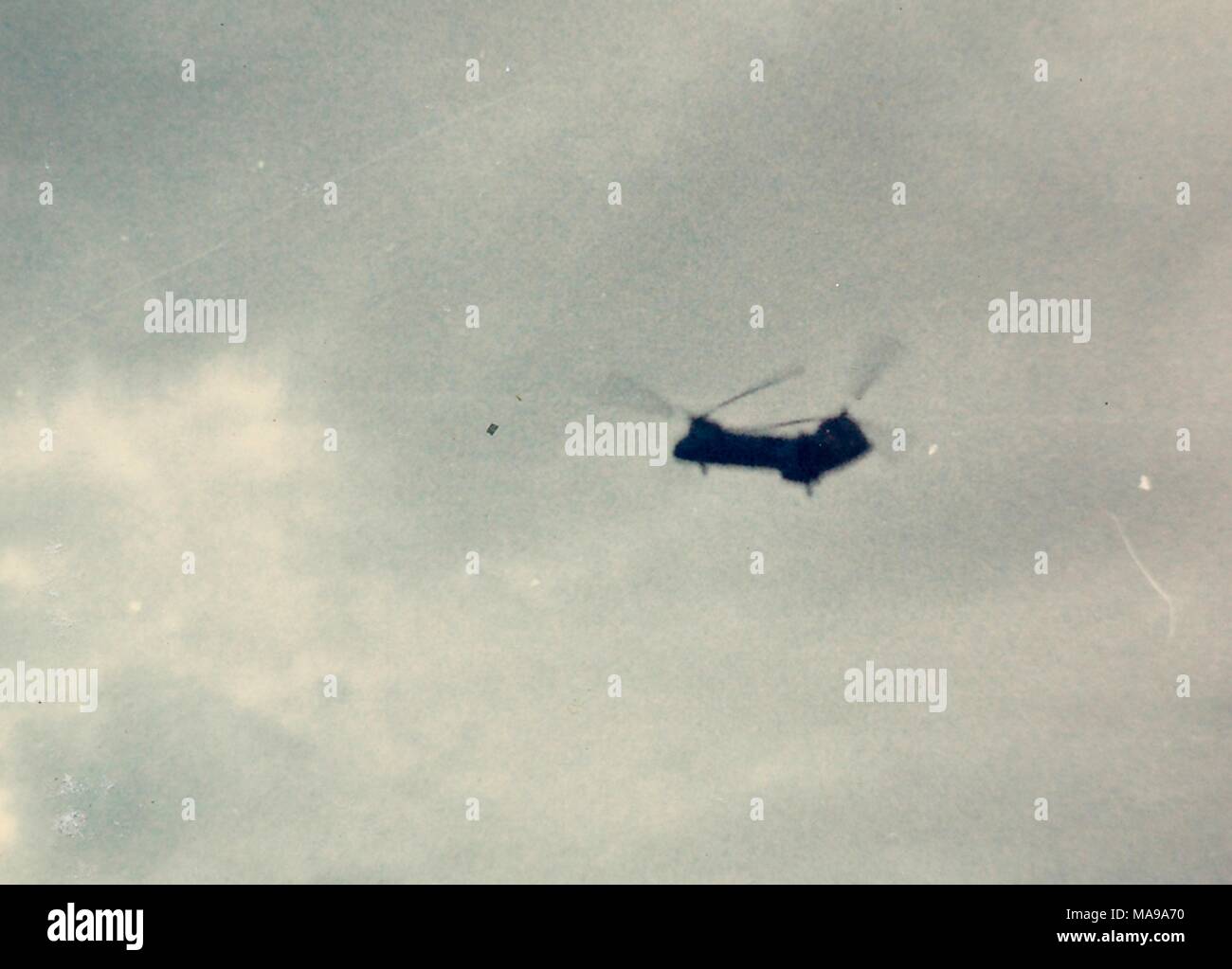 Color photograph showing a tandem rotor helicopter, in midflight