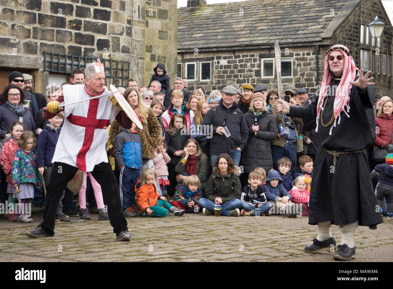 Heptonstall, UK. 30th March, 2018. A traditional Pace Egg play is performed in Heptonstall’s Weavers Square on Good Fridays, attracting hundreds of visitors to the village. The origins are uncertain, but some version of the plays have undoubtedly been performed over many hundreds of years. In the play St George takes on contenders such as Bold Slasher, the Black Prince of Paradine and Hector. Credit: Steve Morgan/Alamy Live News Stock Photo