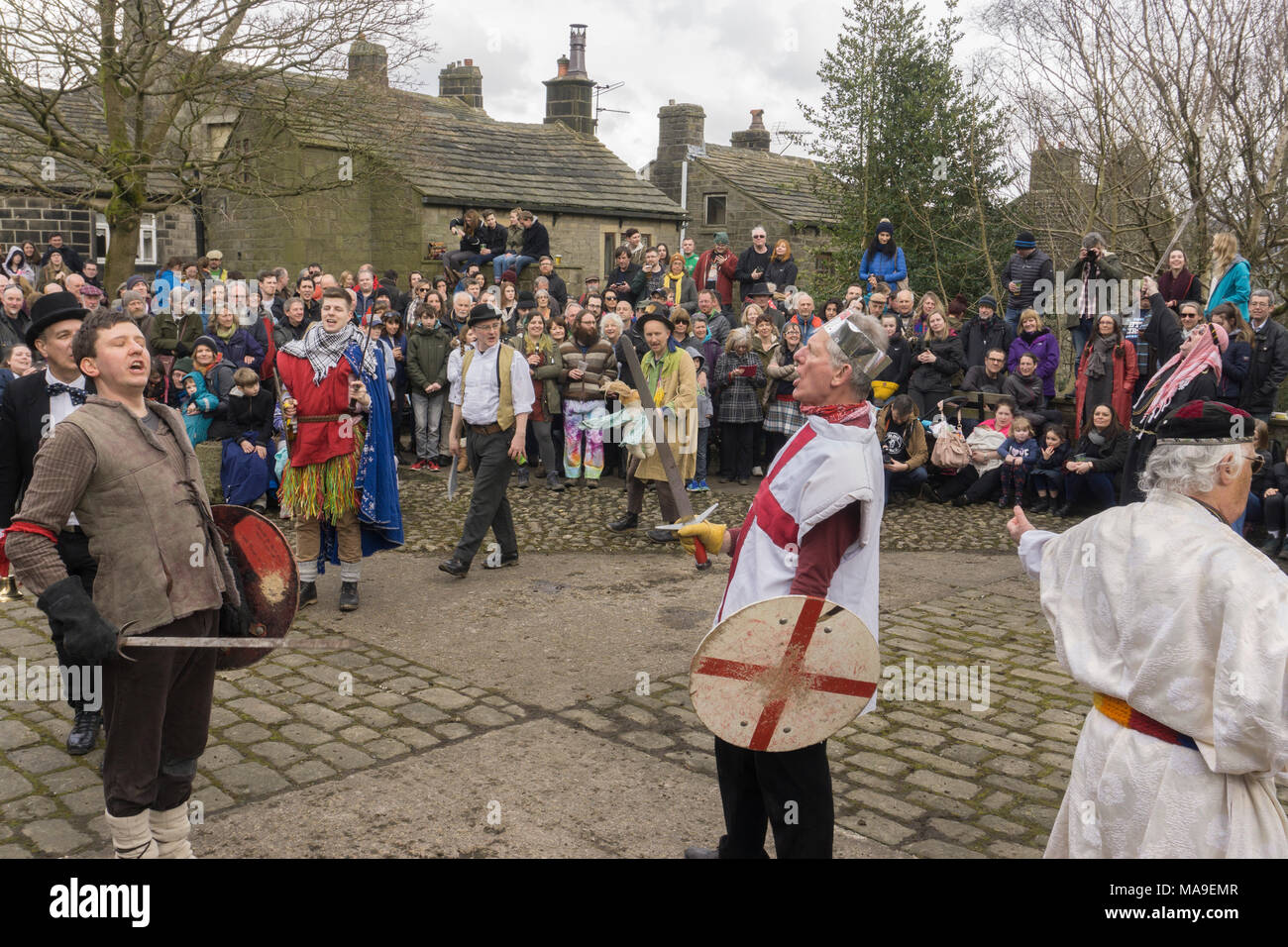 Heptonstall, UK. 30th March, 2018. A traditional Pace Egg play is performed in Heptonstall’s Weavers Square on Good Fridays, attracting hundreds of visitors to the village. The origins are uncertain, but some version of the plays have undoubtedly been performed over many hundreds of years. In the play St George takes on contenders such as Bold Slasher, the Black Prince of Paradine and Hector. Credit: Steve Morgan/Alamy Live News Stock Photo