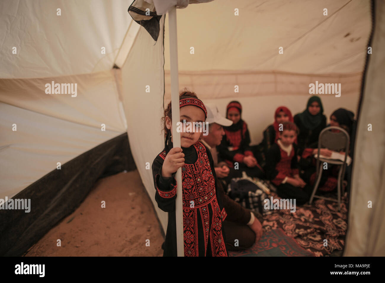 A Palestinian refugee girl stands inside her family's tent during a ...