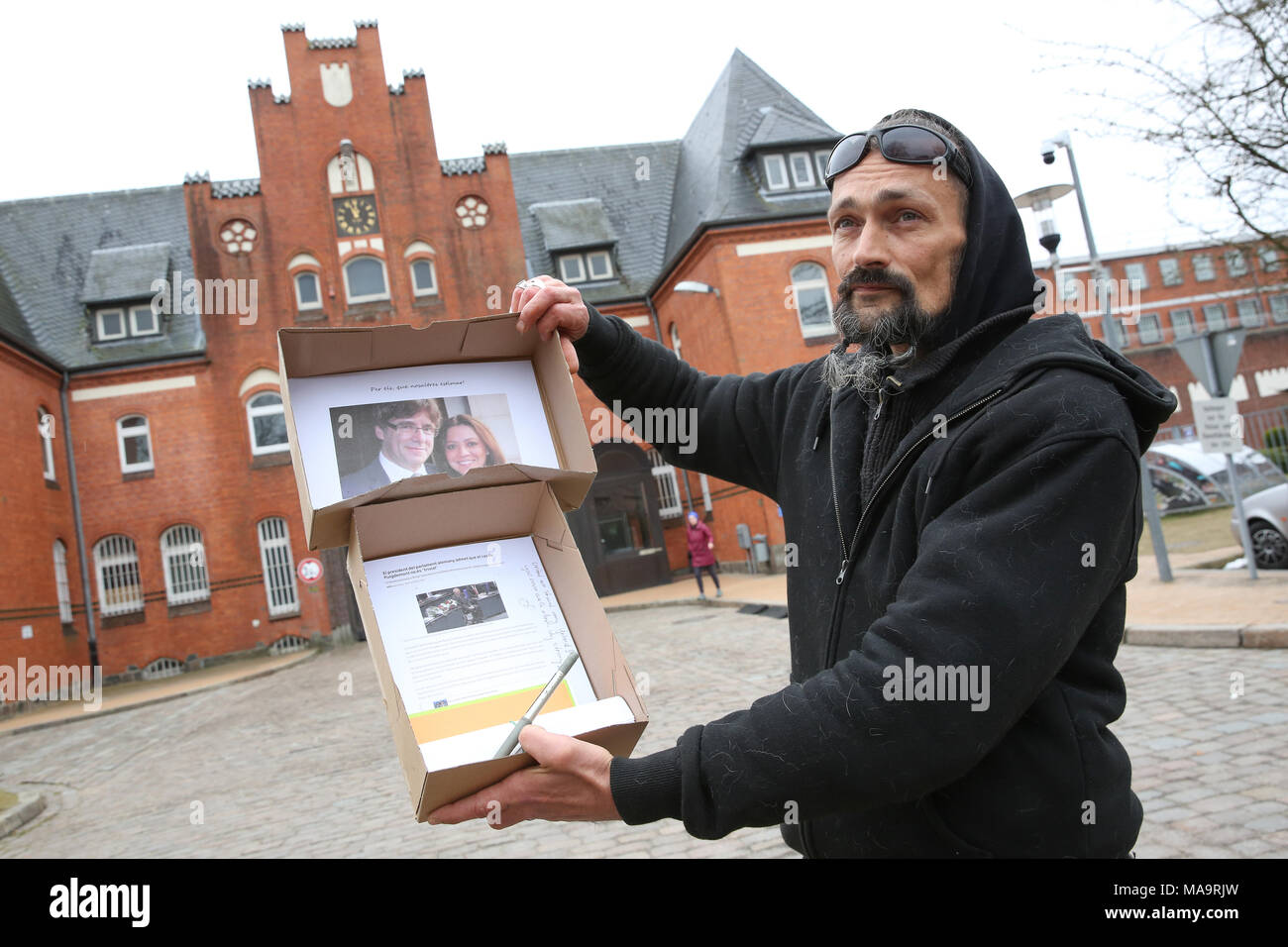 Neumuenster, Germany, 31 March 2018.Activist Gerdson Hengist standing with a "care package" in front of the correctional facility in Neumuenster, where Catalonia's former president Carles Puigdemont is currently in custody since 25 March. The attempt to deliver the package, containing newspaper articles and solidarity messages, failed. Photo: Bodo Marks/dpa Stock Photo