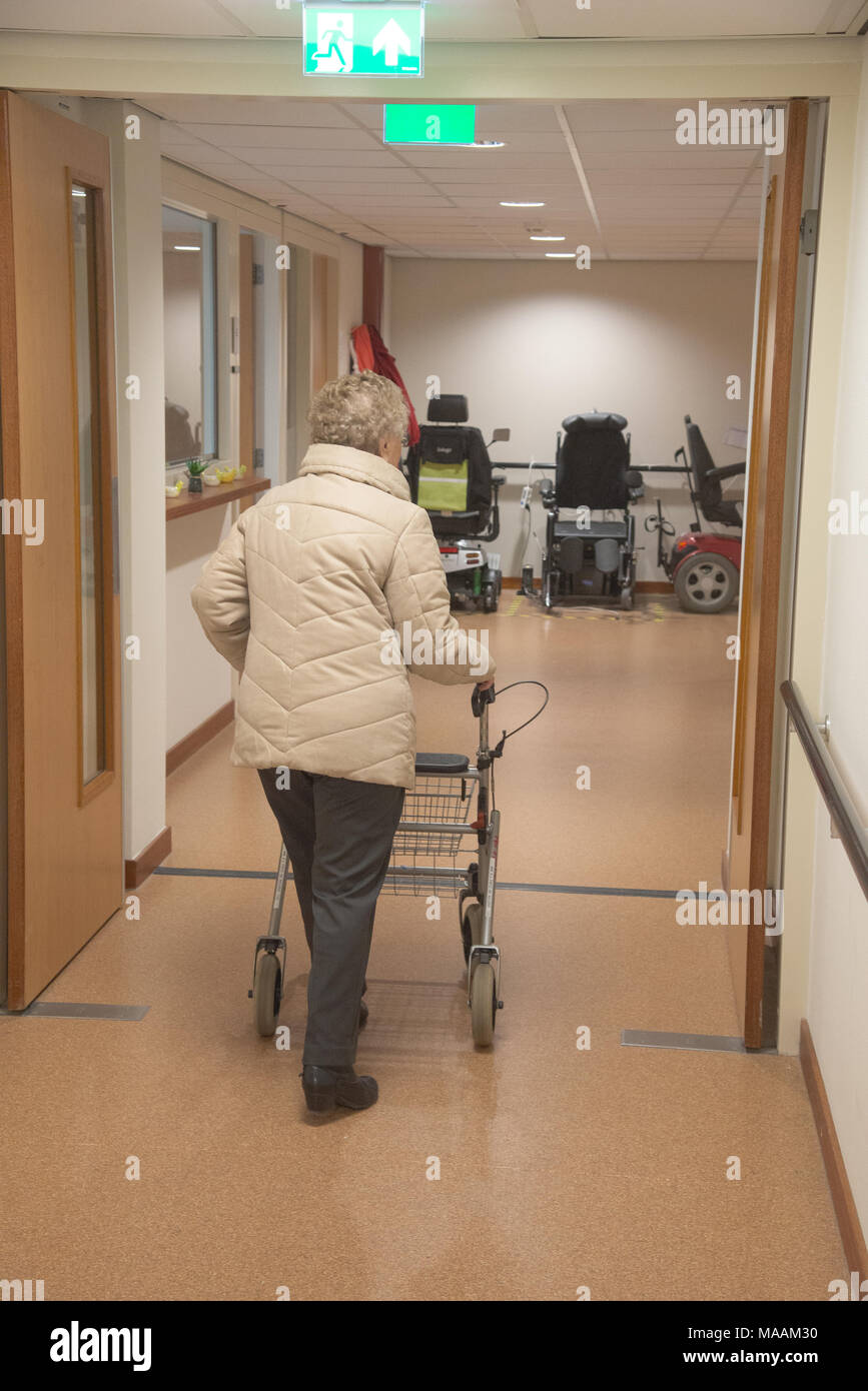 elder woman in house for the elderly walking with aid, Holland Stock Photo