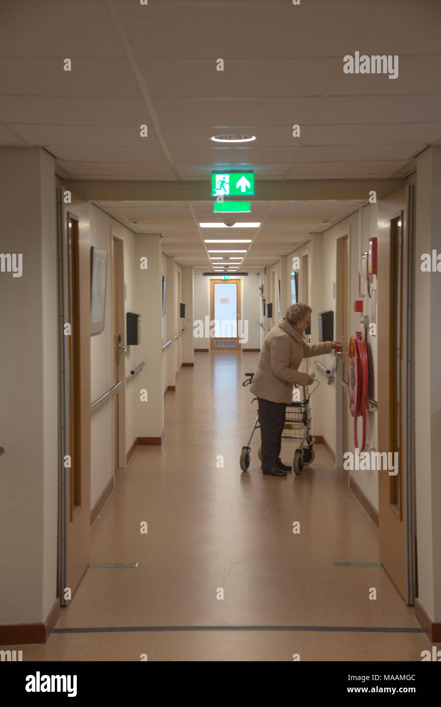 elder woman in house for the elderly entering room, holland Stock Photo