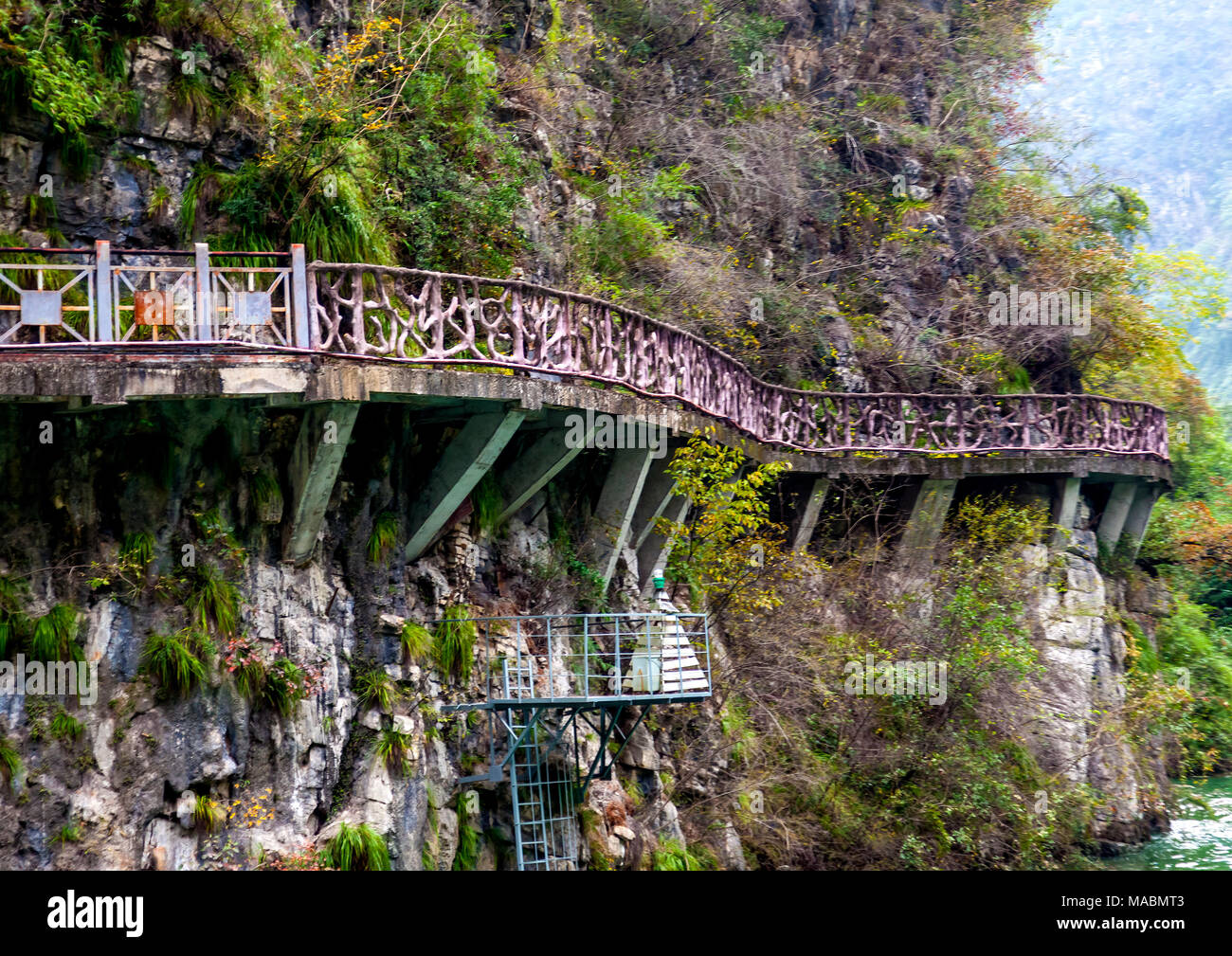 Raised footpath clings to mountain rock wall as it follows Ba Wu Gorge off the Yangtze River in China Stock Photo