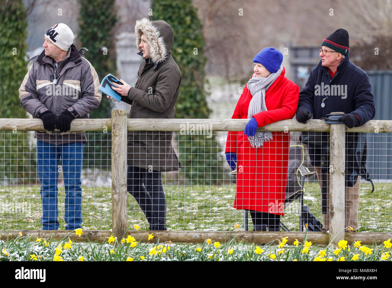 Cold and heavy coated spectators trackside at the wintery Goodwood 76th Members Meeting, Sussex, UK. Stock Photo