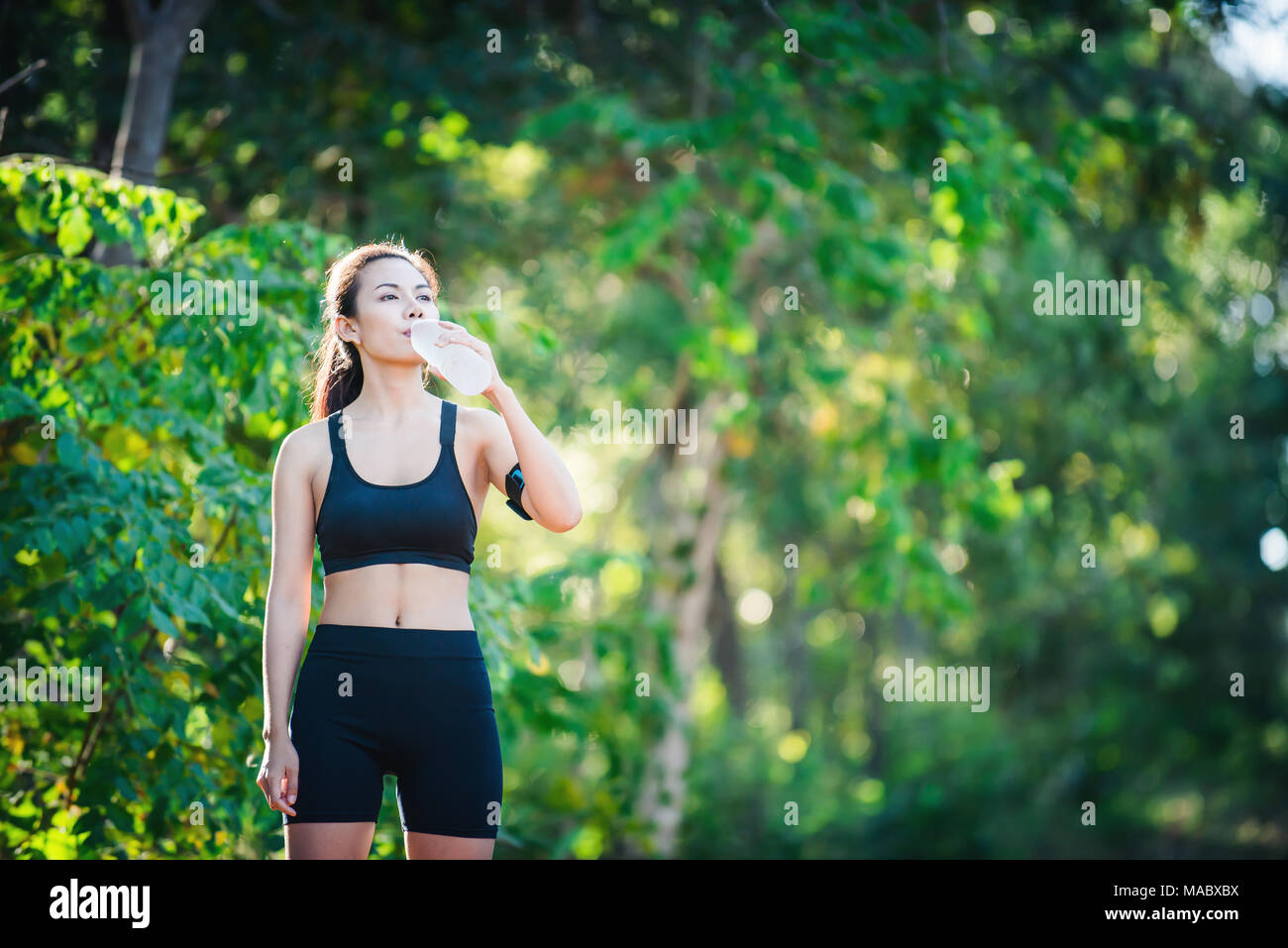 Premium Photo  Fitness young woman drinking water from bottle. muscular  young female at gym taking a break from workout.