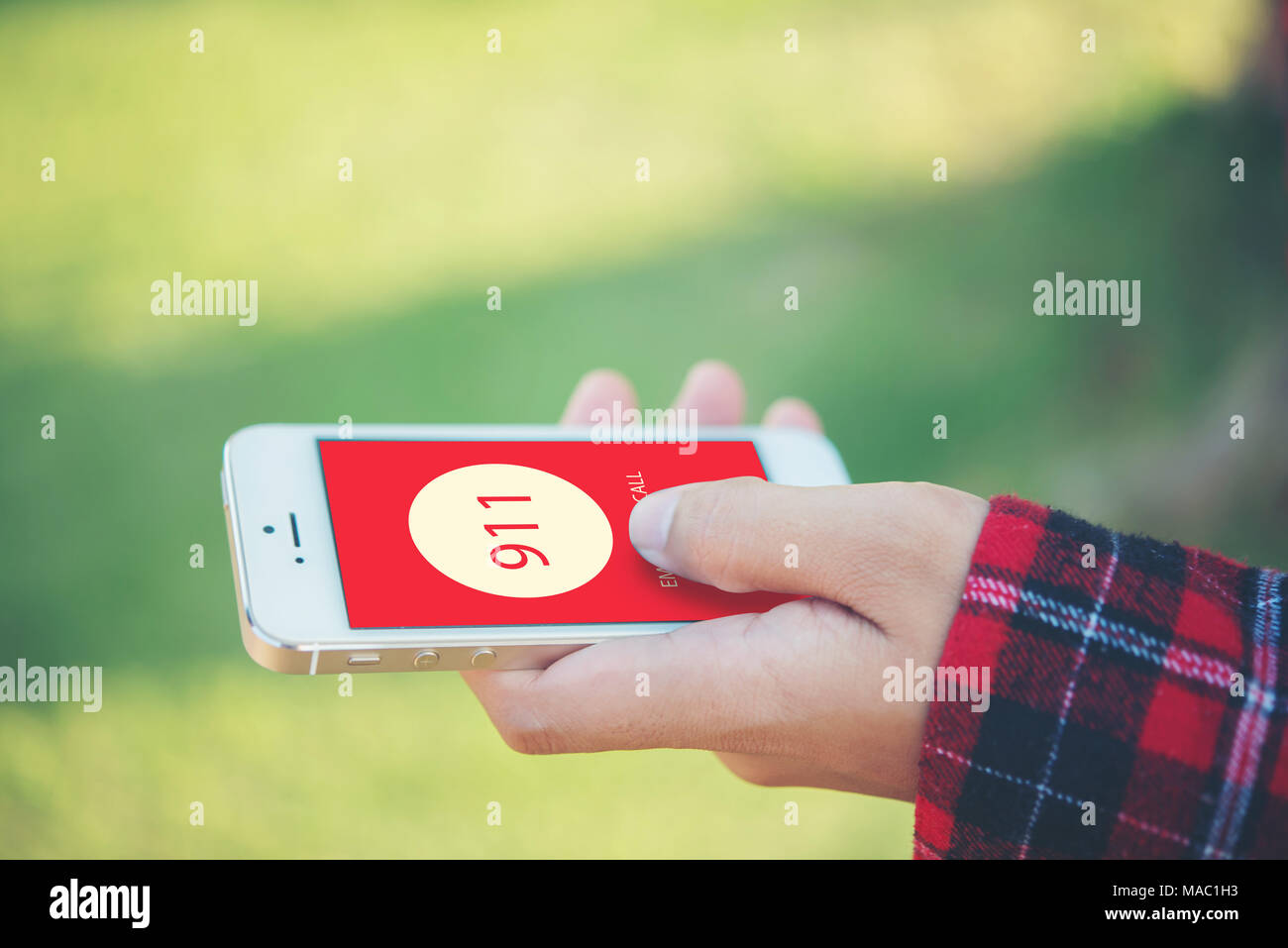 Woman holding a smartphone dialing emergency number on screen. Graphics