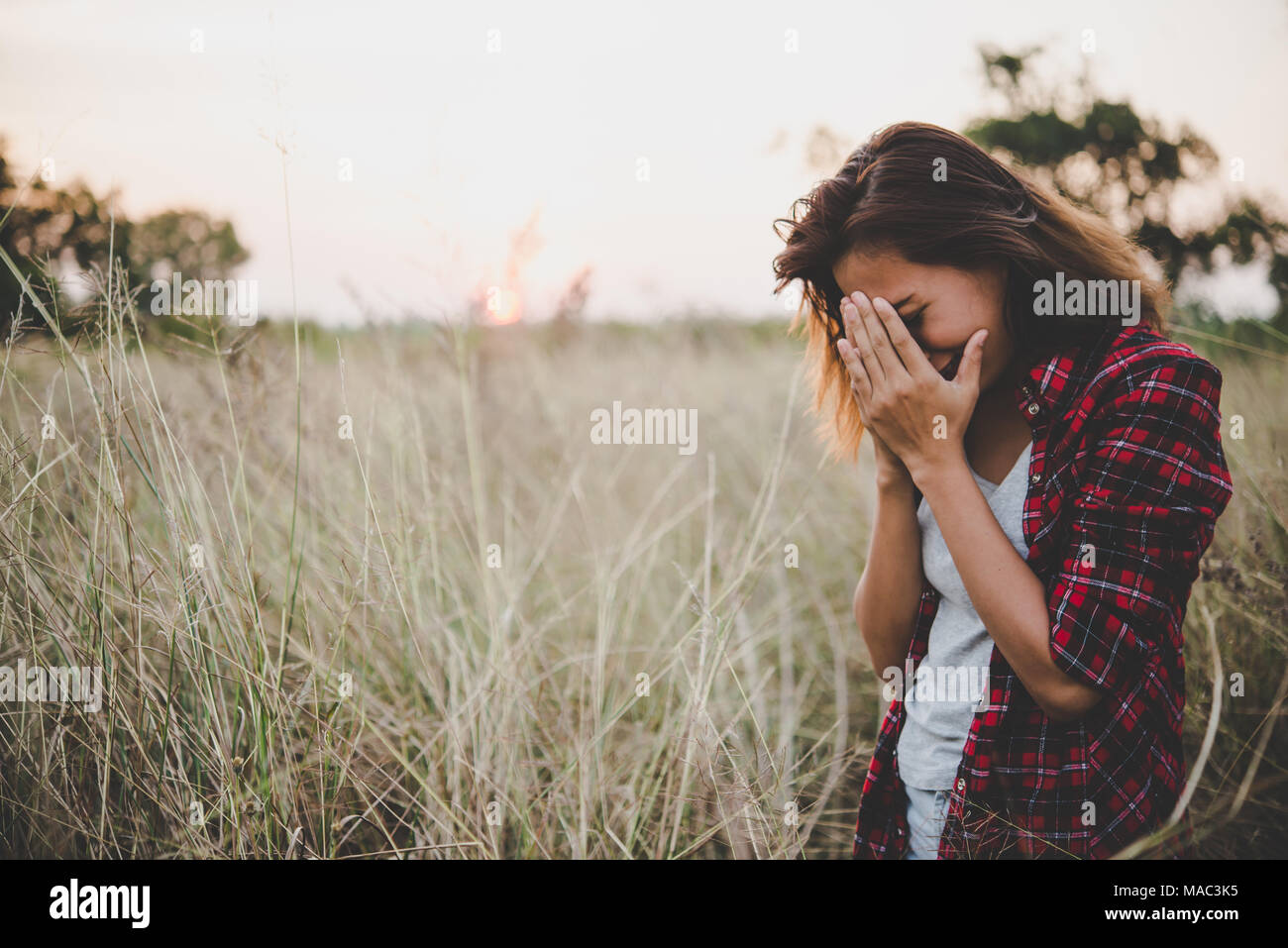 Close up of sad young woman in a field Stock Photo - Alamy