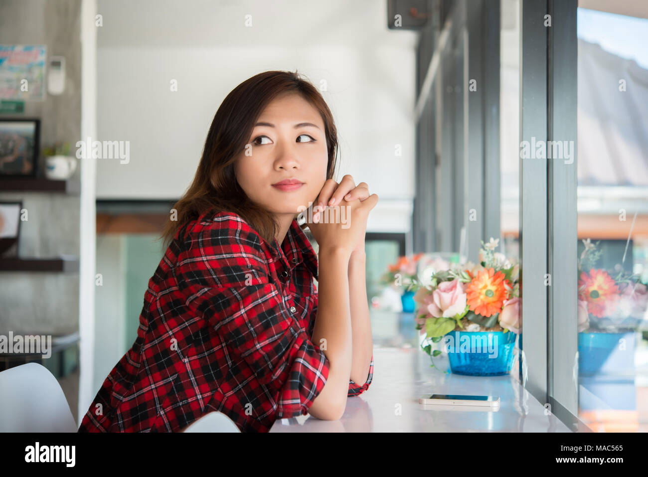 Beautiful asian woman sitting in the cafe , feeling happy and smiley ...