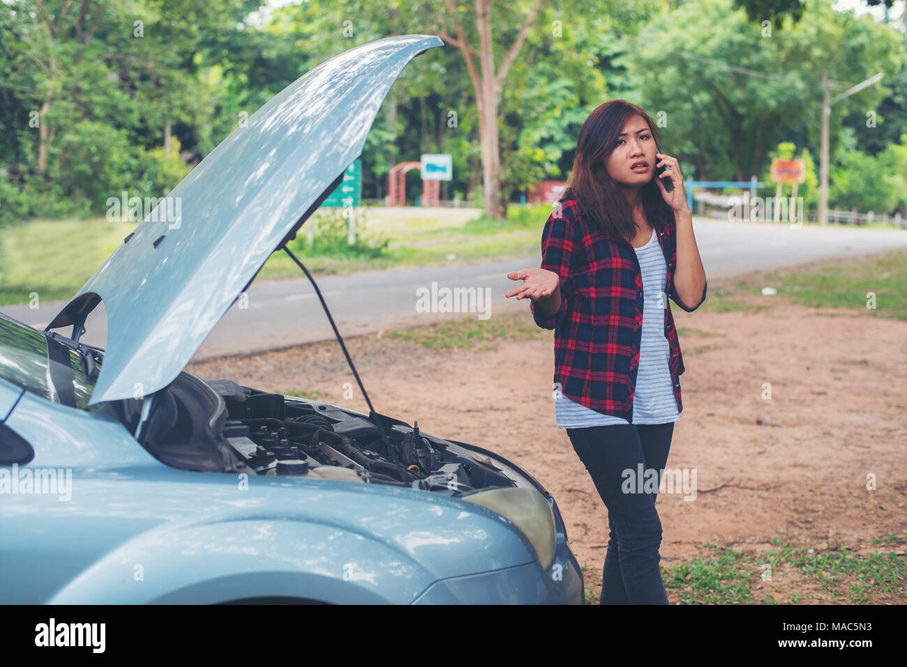 Young woman with car breaks down and she is calling the emergency ...