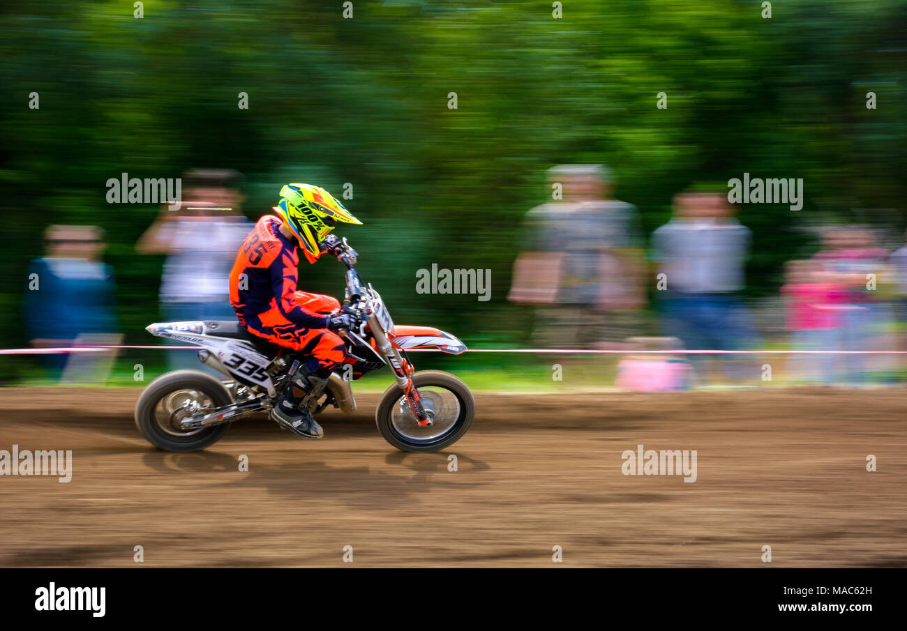 Uzhgorod, Ukraine - May 21, 2017: Junior MX rider turns on a corner. Motion blur with flying dirt. TransCarpathian regional Motocross Championship Stock Photo
