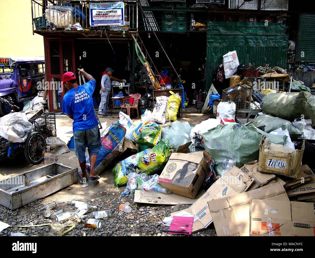 ANTIPOLO CITY, PHILIPPINES - MARCH 28, 2018: Workers of a junk shop or materials recovery facility sort through all kinds of recyclable materials. Stock Photo