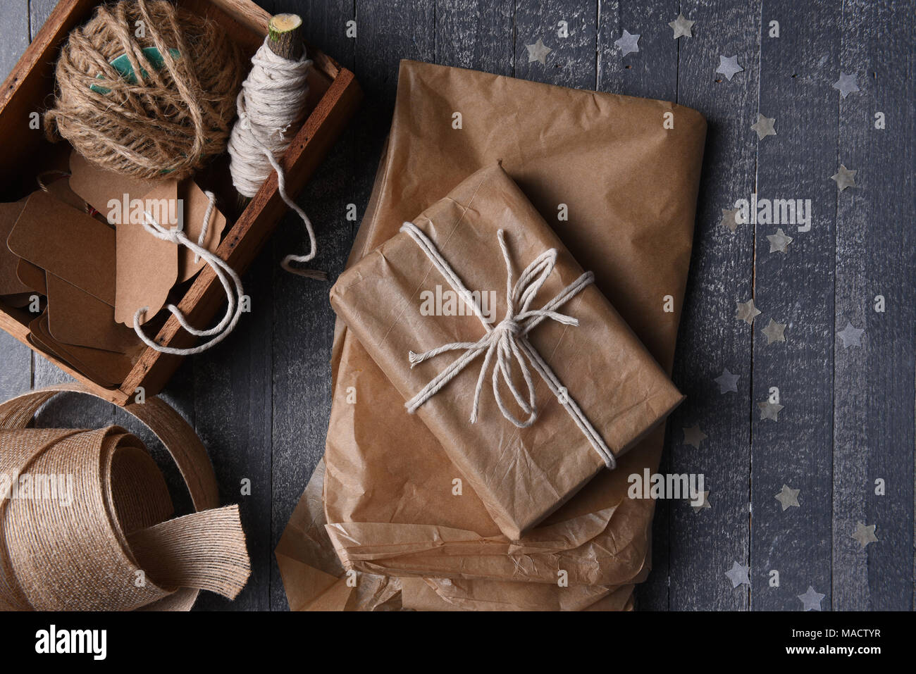 High angle shot of plain brown paper gift wrapping supplies with paper stars. Stock Photo