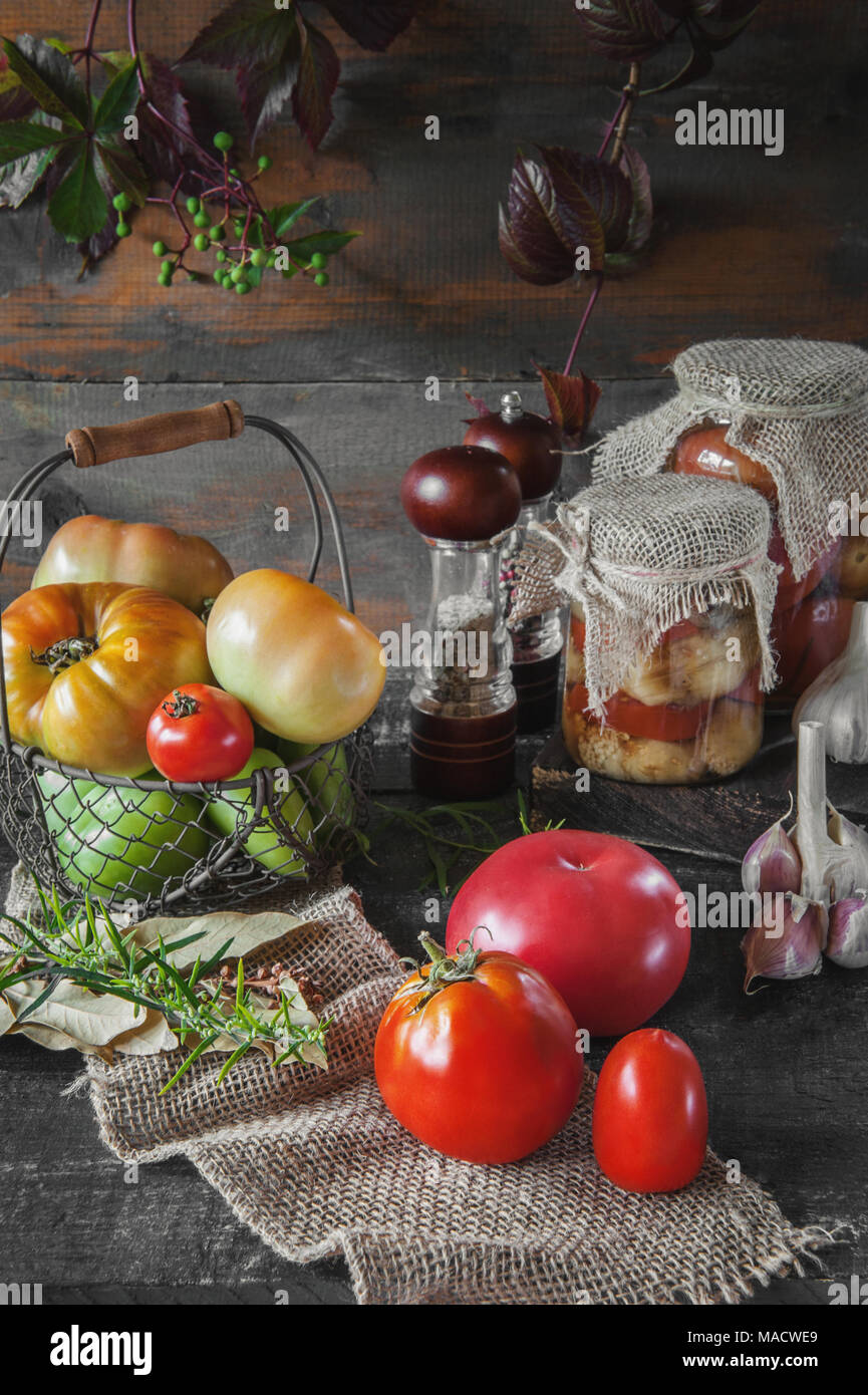 Homemade canned tomatoes in glass jars in a rustic style. The concept of cultivation, harvesting