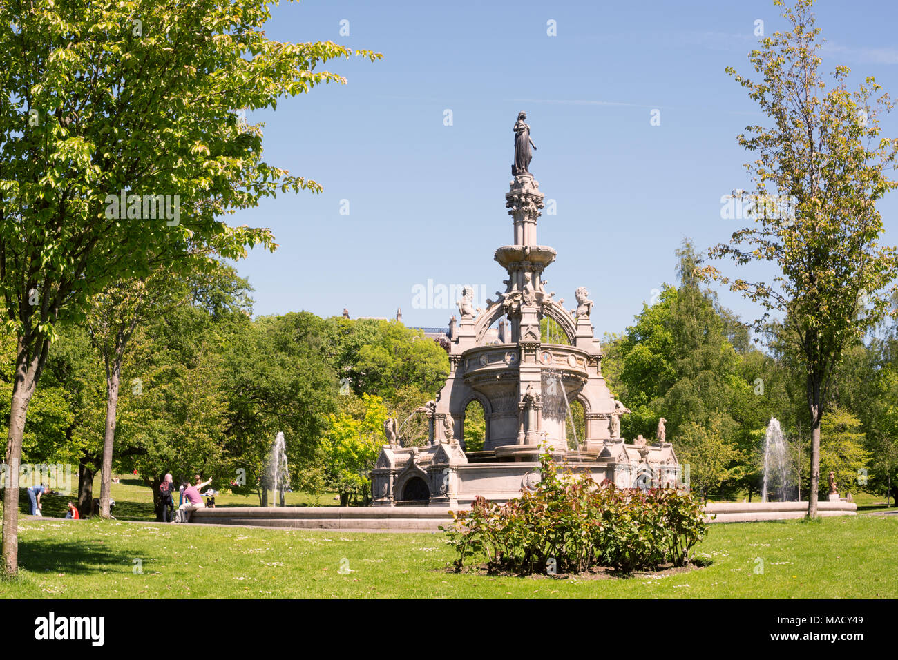Families with children enjoying sunny weather near the Stewart memorial fountain in the Kelvingrove Park of Glasgow, Scotland, UK Stock Photo