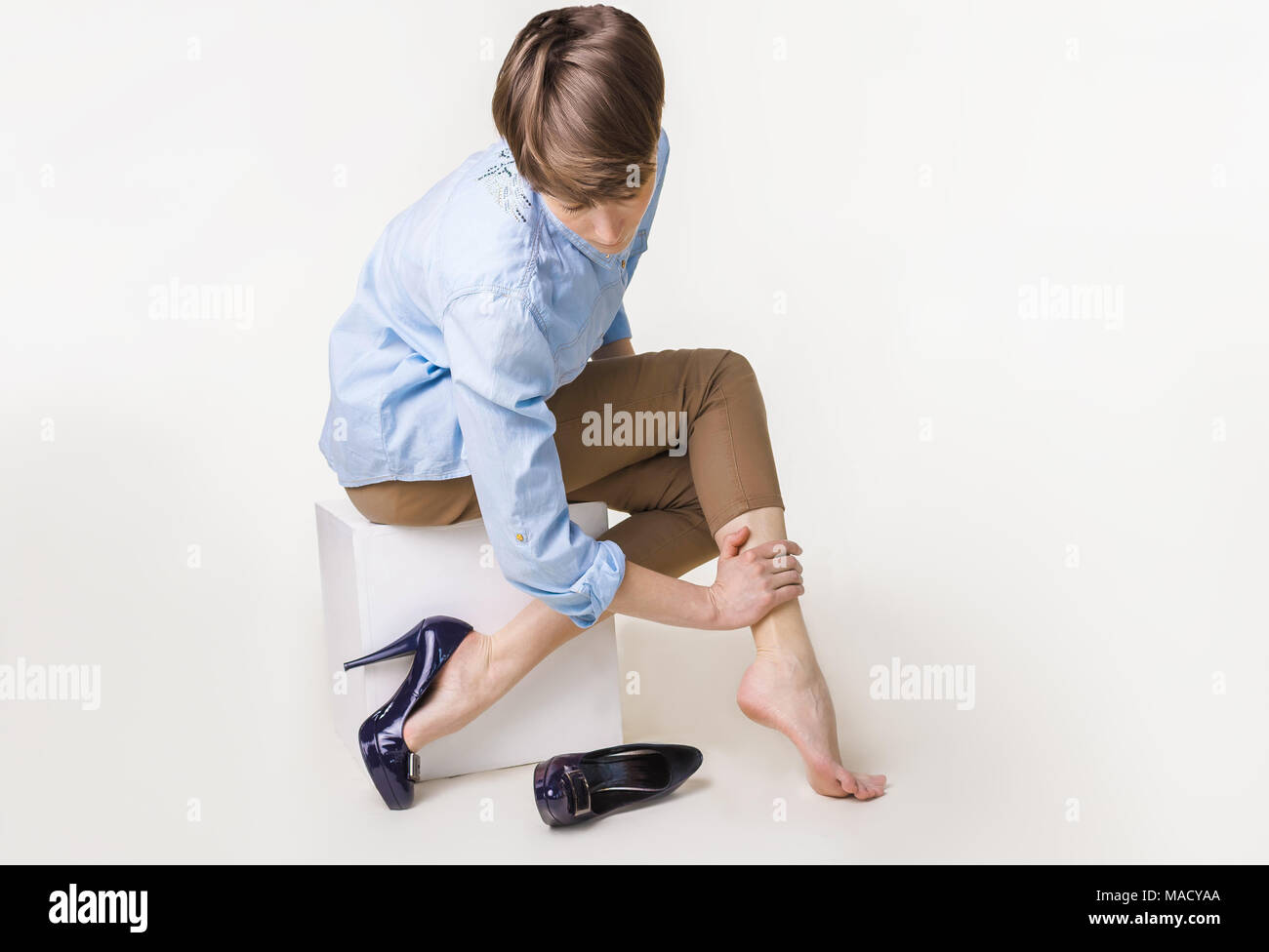 Young woman in high heels massaging her tired legs Stock Photo Alamy