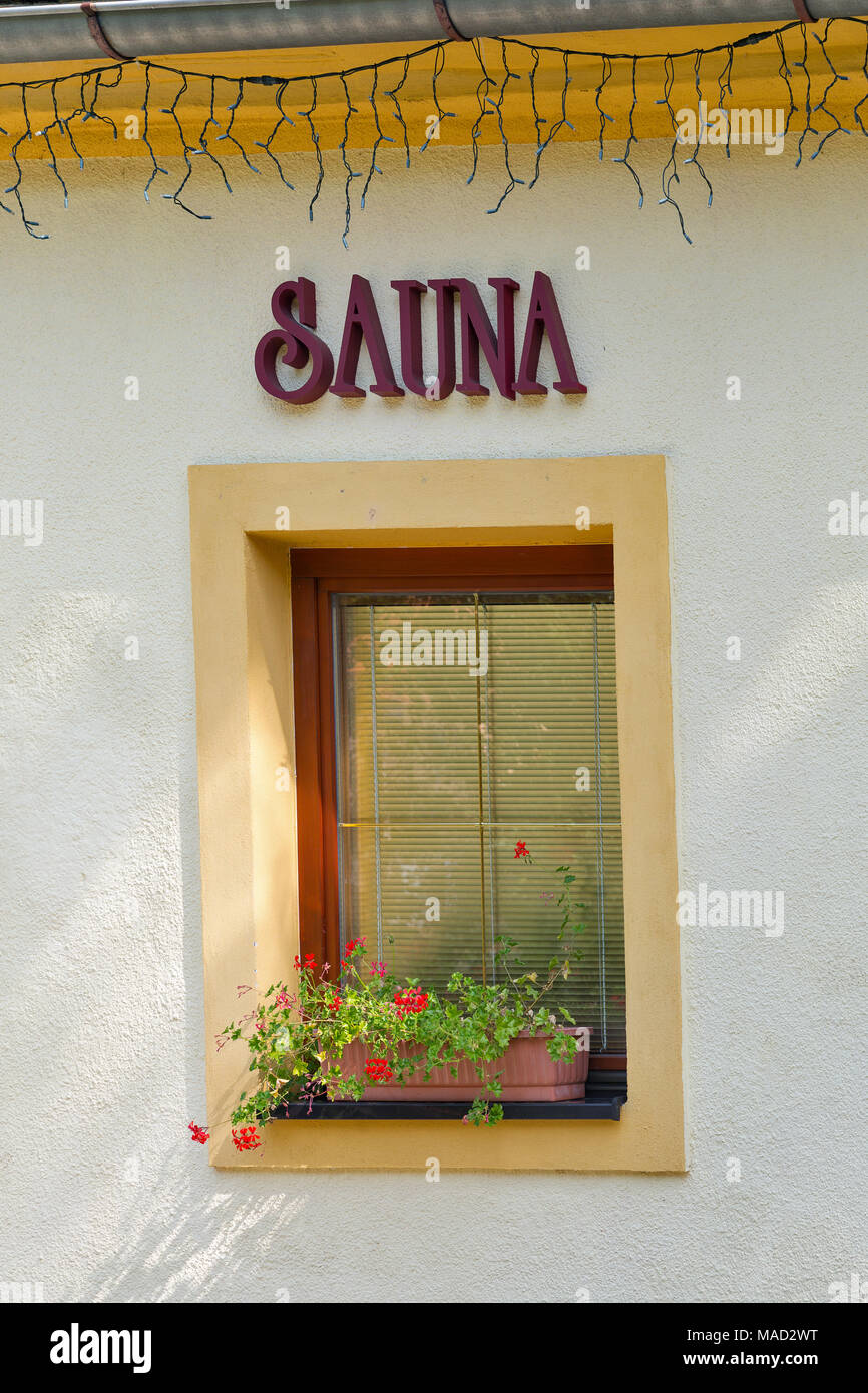 Sauna sign outdoor on building wall with window Stock Photo