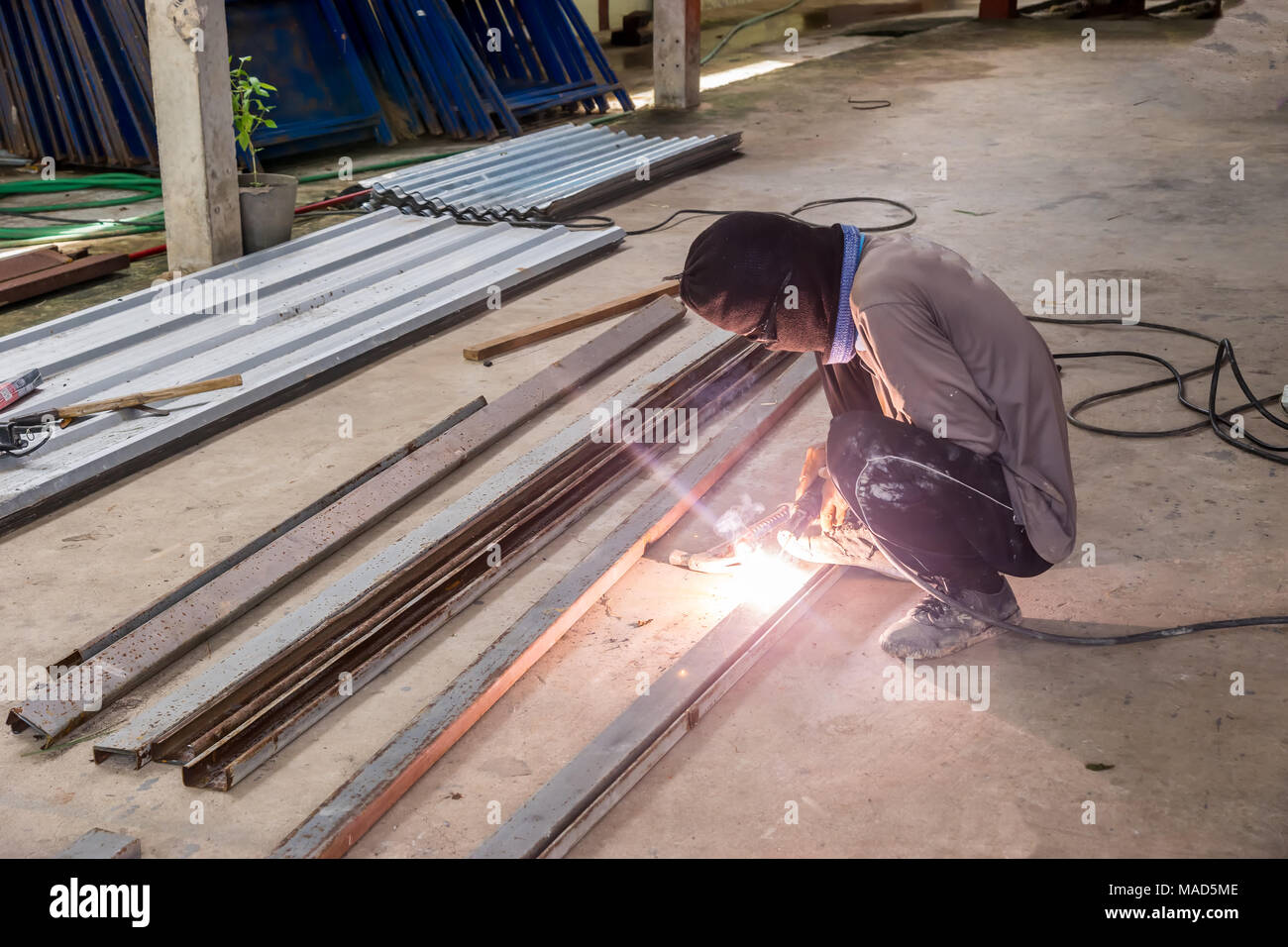 Un-identified worker man welding metal rod for house construction Stock Photo
