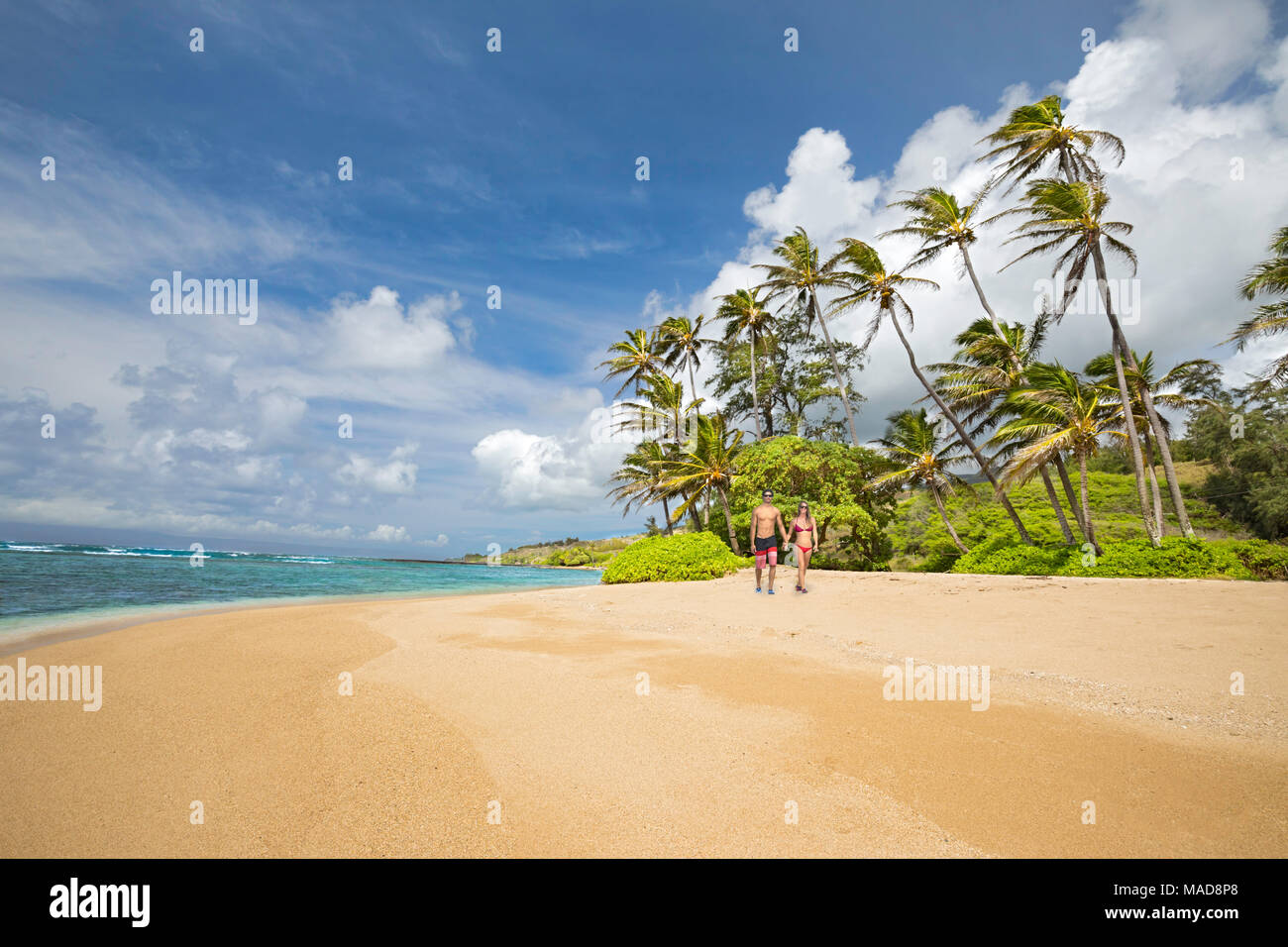 A young couple walk on Twenty Mile Beach on the island of Molokai, Hawaii, United States of America, Pacific. Stock Photo
