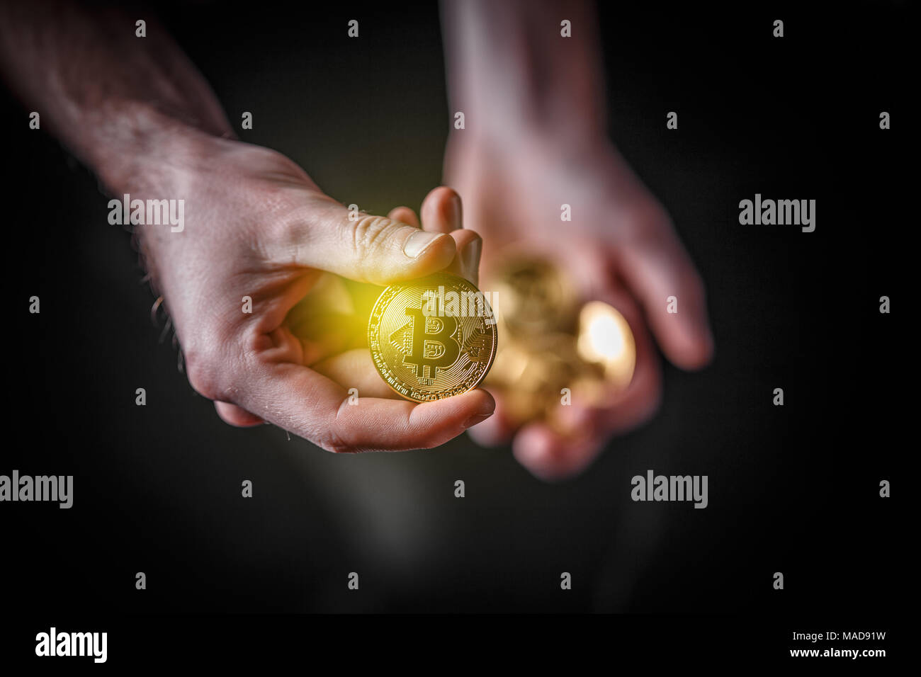 Bitcoin in man's hand, closeup. Cryptocurrency investment concept. Stock Photo