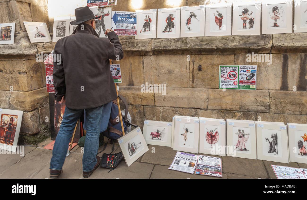 A artist works on his prints on display in York,North Yorkshire,England