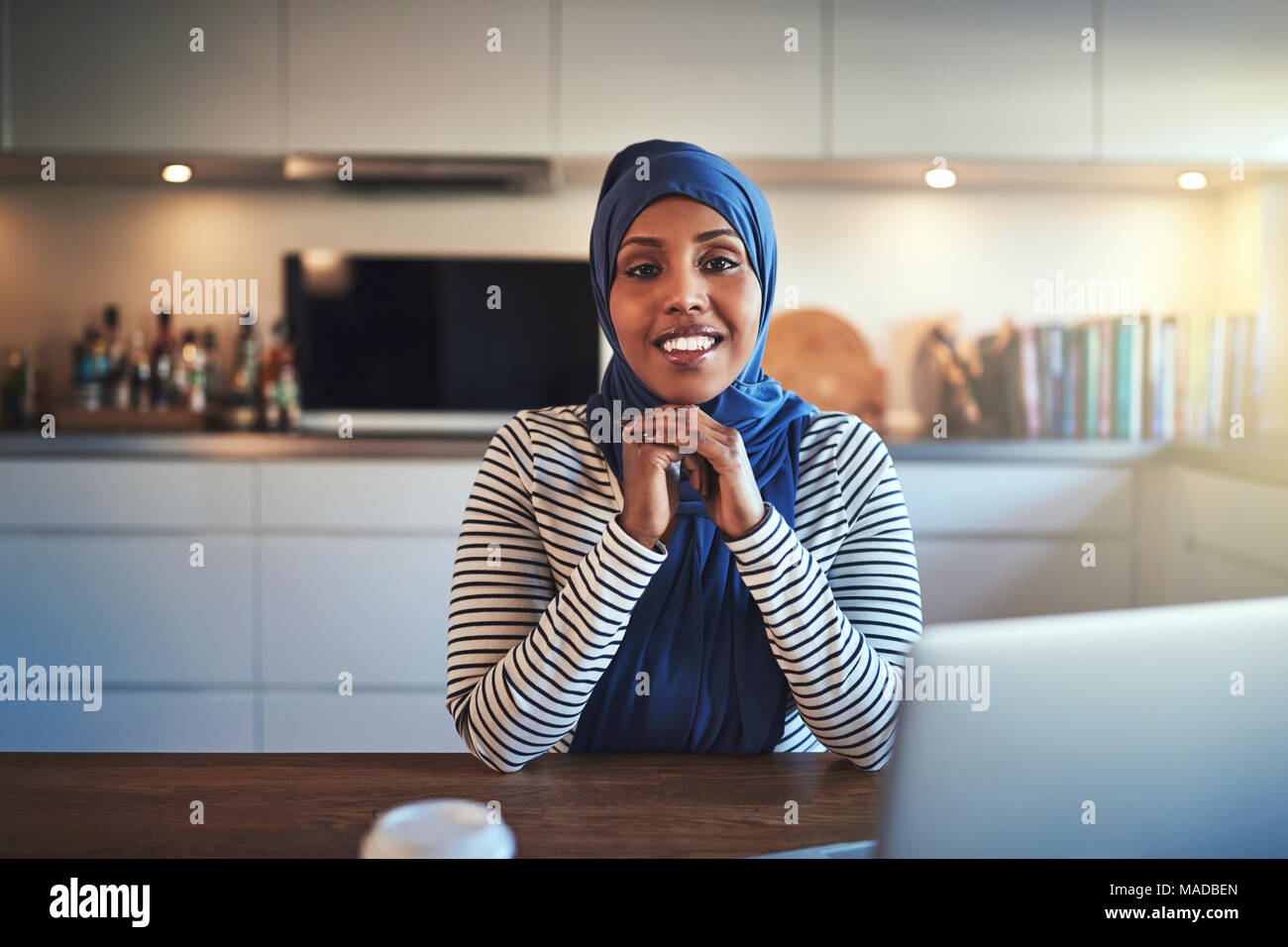Confident young Arabic female entrepreneur wearing a hijab working on a ...