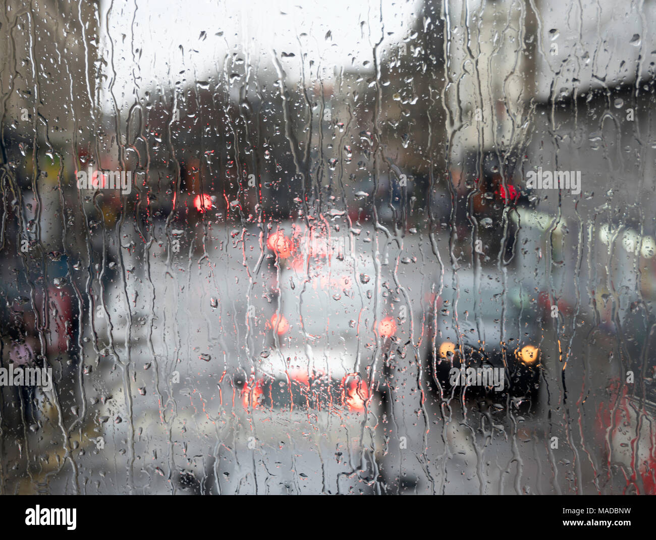 Road traffic seen through heavy rain on window, Newcastle city centre, north east England, UK Stock Photo