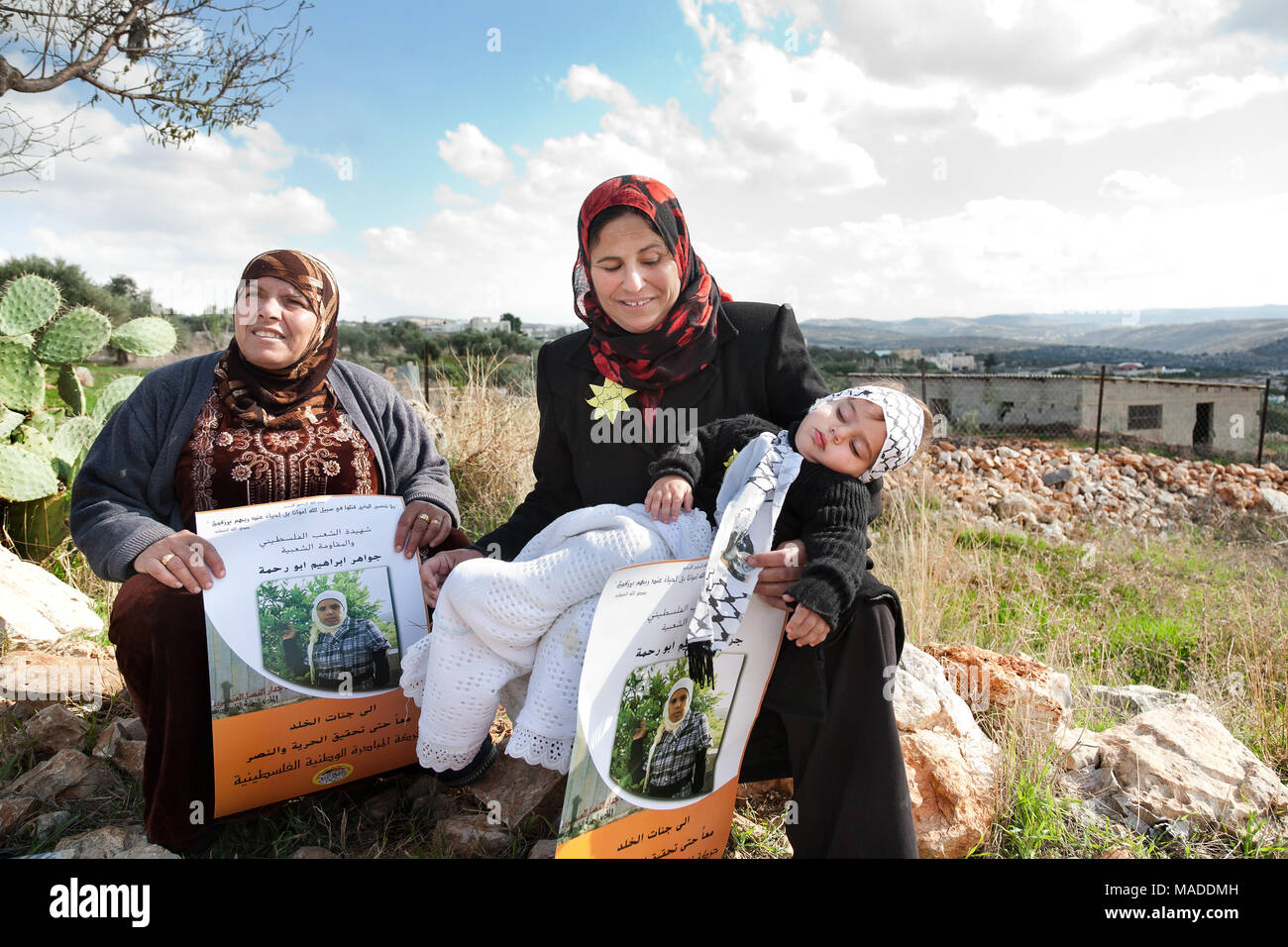 Bilin, Palestine, January 7 2011: Palestinian women and a toddler hold posters of Jawaher abu Rahma, who is thought to die in consequence of tear gas  Stock Photo