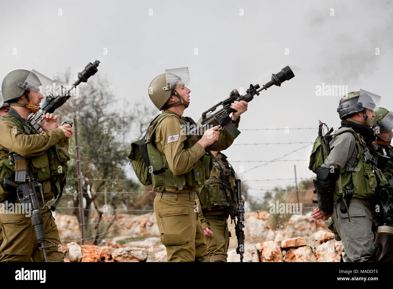Bilin, Palestine, December 31, 2010: Israel Defence Force is shooting tear gas during weekly demonstrations against Palestinian land confiscation and  Stock Photo