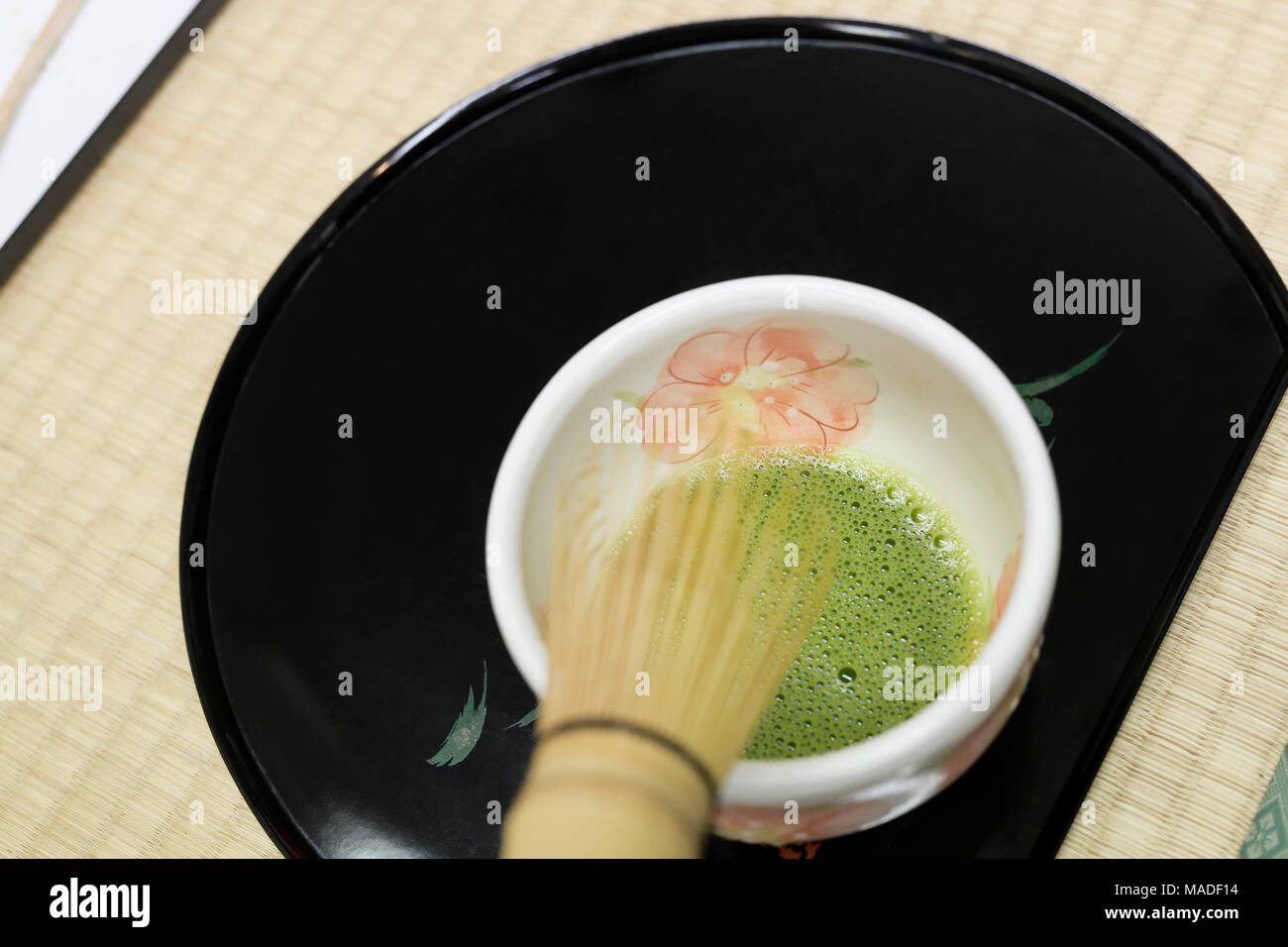 Japanese Matcha powdered green tea sampling cup with a bamboo whisk, tea tasting ceremony in Uji, Kyoto Prefecture, Japan Stock Photo