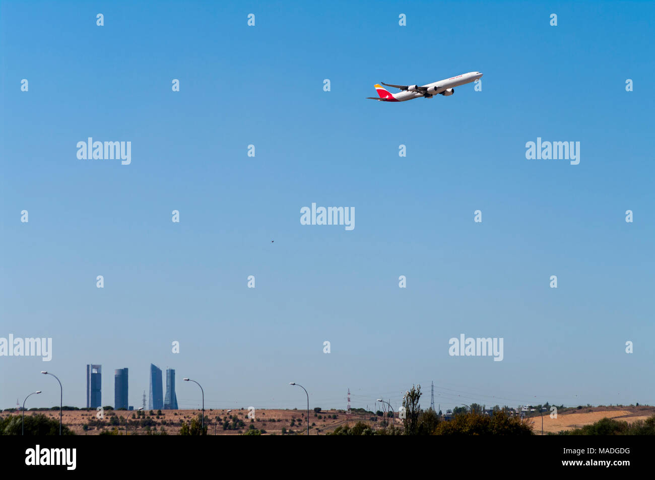 Avión despegando desde el Aeropuerto de Barajas con los rascacielos de Madrid al fondo. España Stock Photo