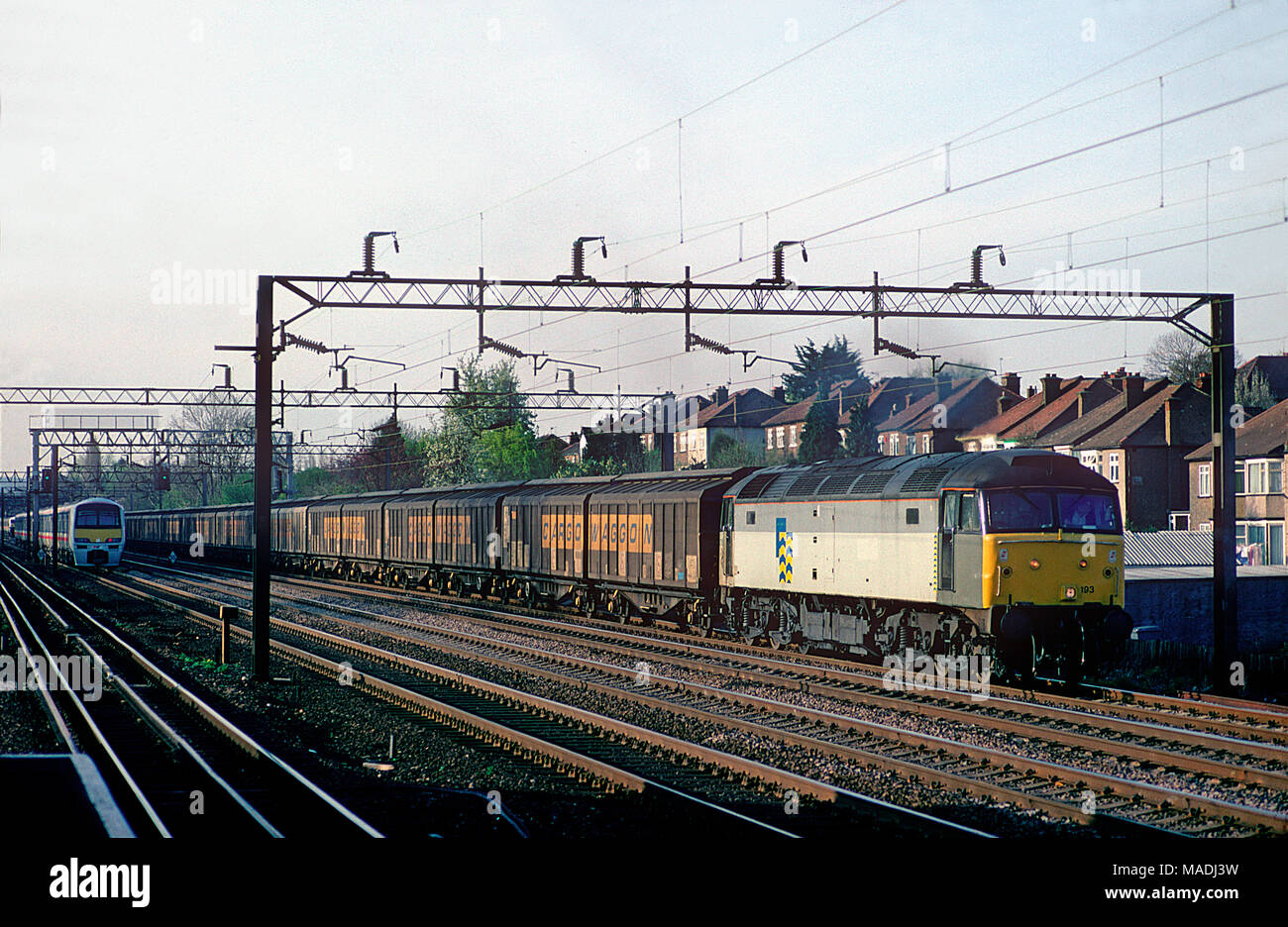 A class 47 diesel locomotive number 47193 working a lengthy train of cargo wagons at South Kenton on the 11th April 1994. Stock Photo