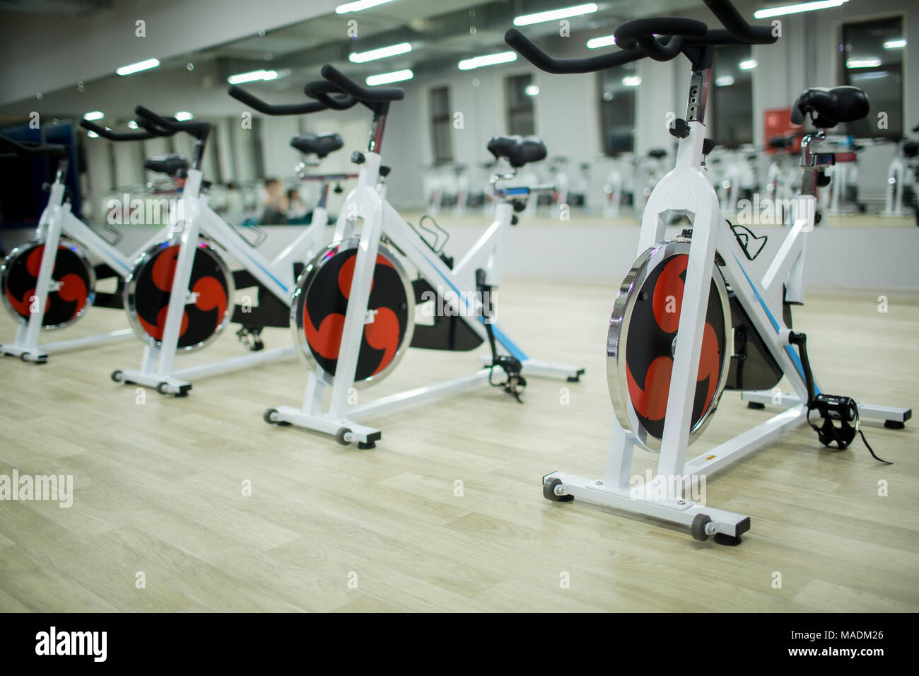 Row of new sports bikes for exercising in large modern fitness center or gym Stock Photo