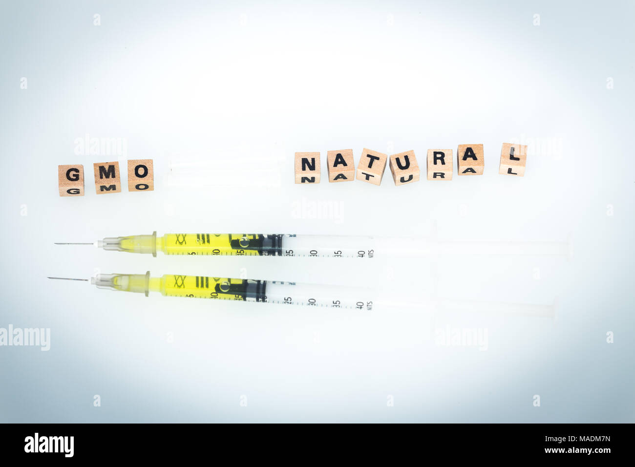 Syringes and GMO and Natural inscriptions as a symbol of modified Stock Photo