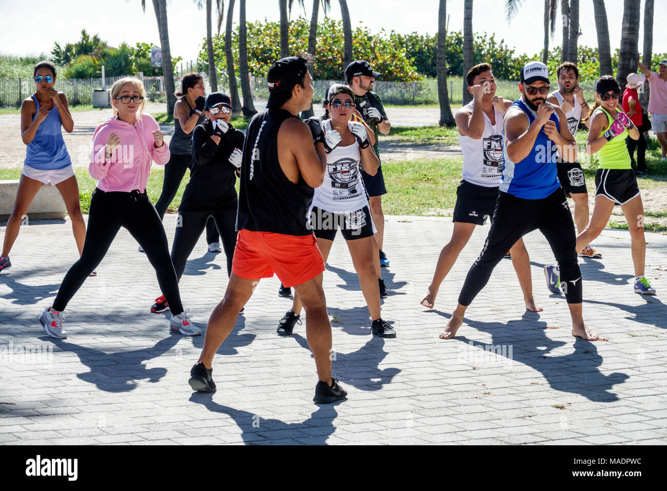 Miami Beach Florida,South Beach,Lummus Park,Ocean Drive,fitness,exercise,trainer,man men male,woman female women,class session,Hispanic,immigrant immi Stock Photo