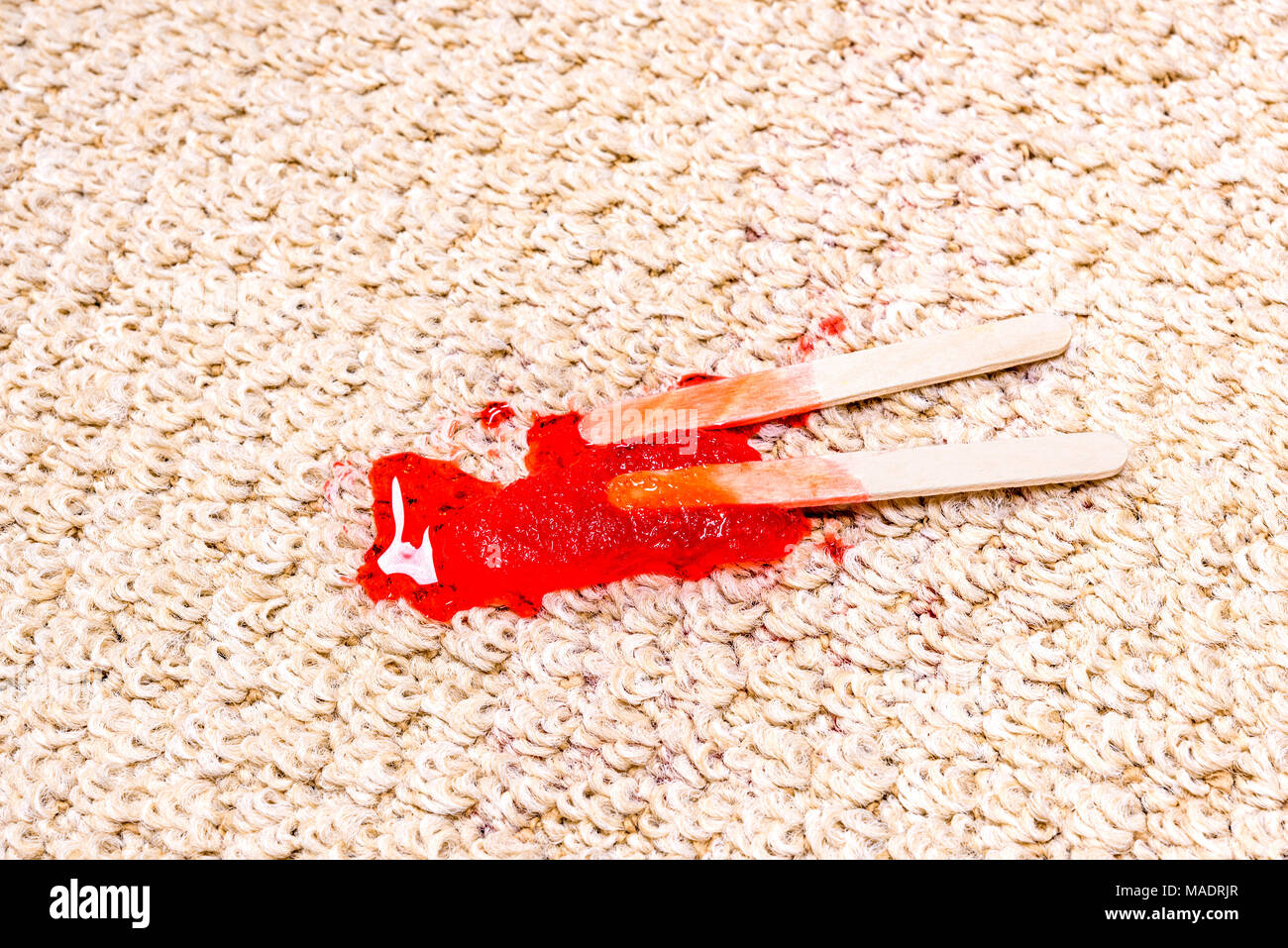 A time lapse of a melting popsicle on white carpet shows the icy treat melt into a sticky juice and absorb right into the carpet. Stock Photo