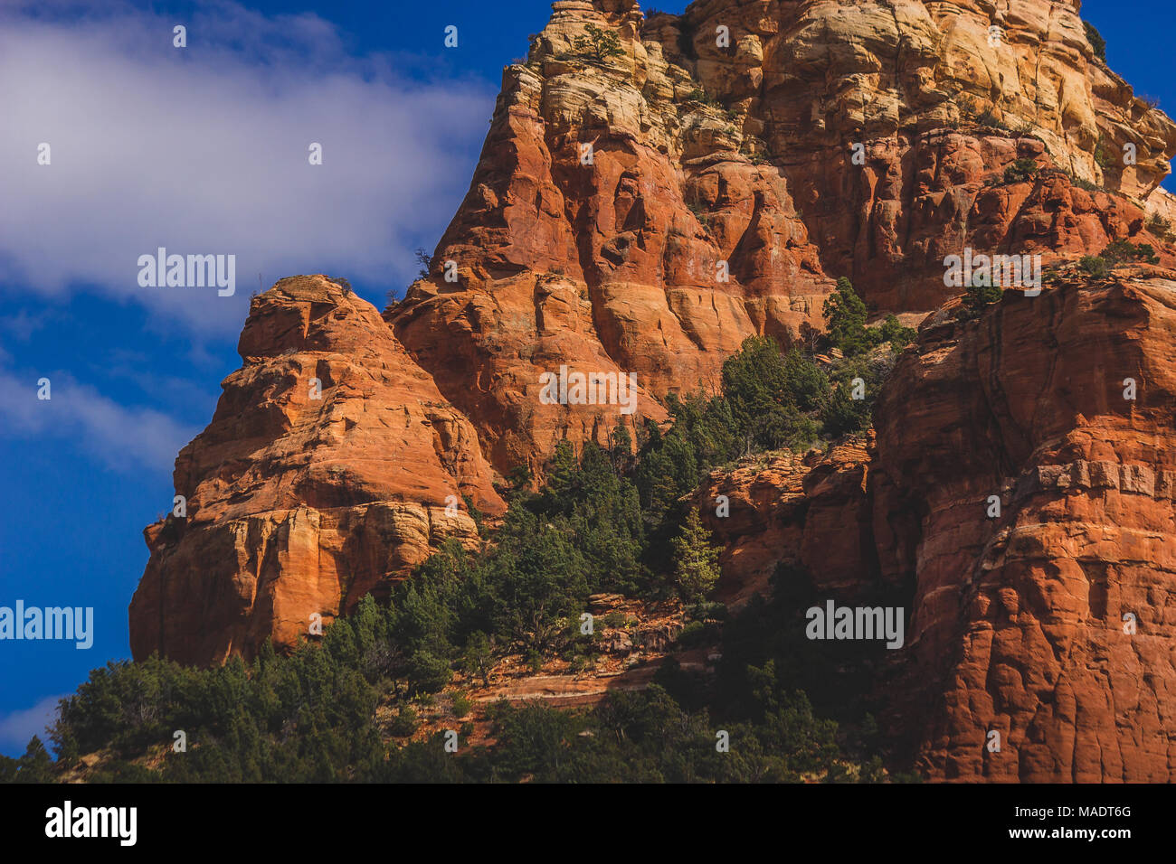 Detailed view of Capitol Butte (aka Thunder Mountain) red rock formation from Dry Creek Vista on a sunny day with blue sky and clouds, Sedona, Arizona Stock Photo