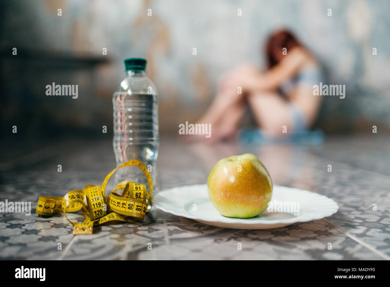 Water, apple and measuring tape, anorexic woman Stock Photo
