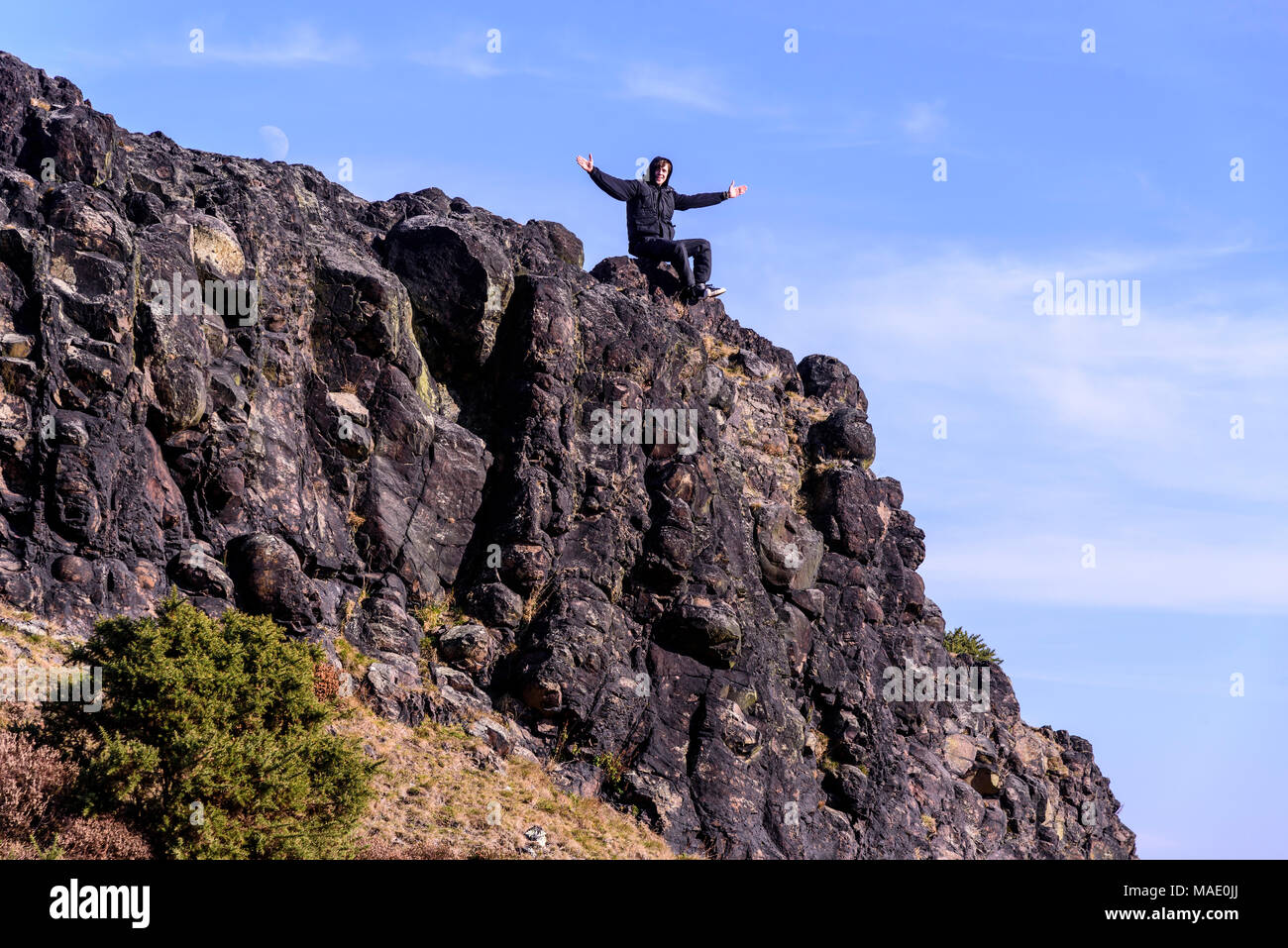 Youth celebrates climbing hill. Stock Photo