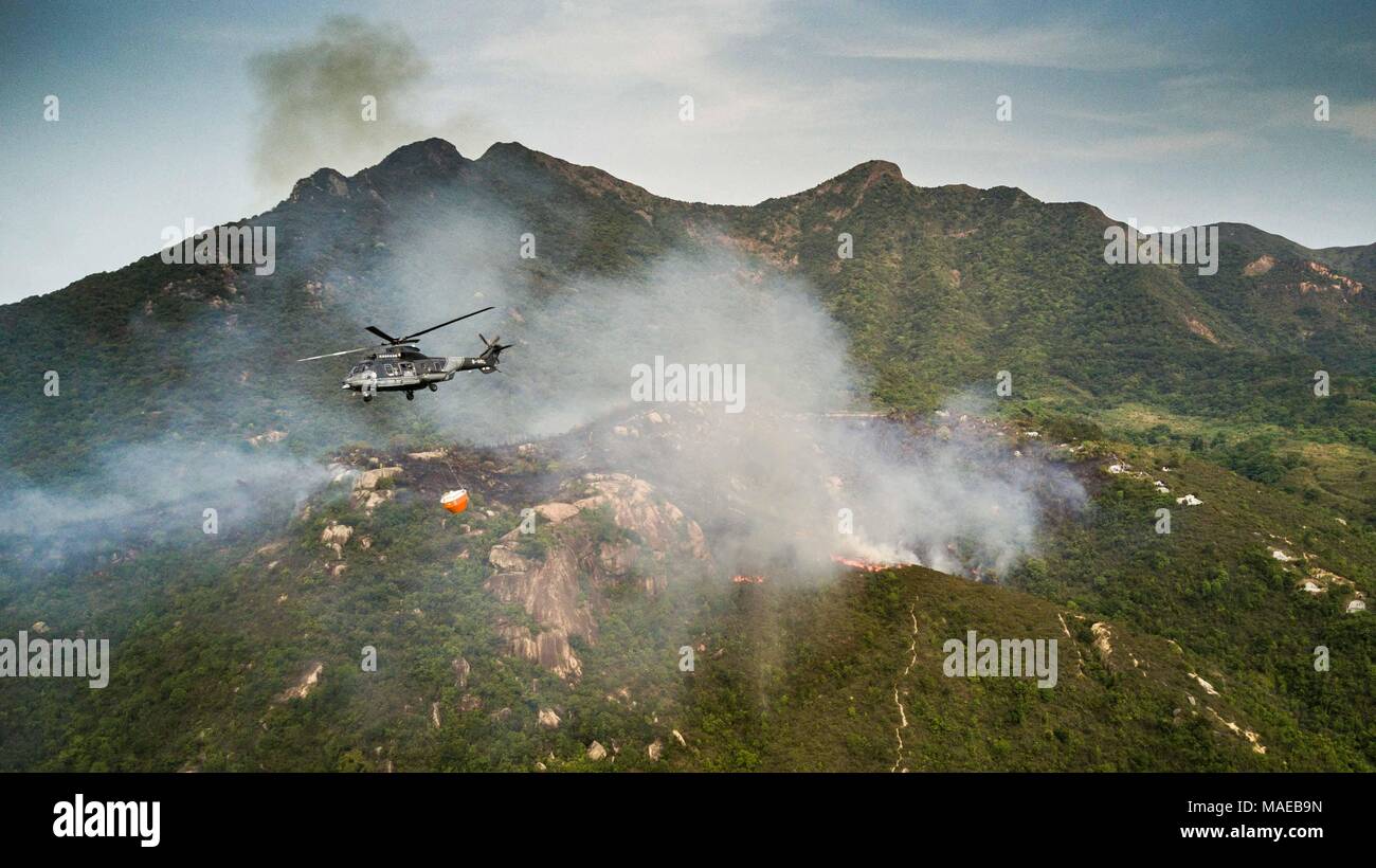 Hong Kong, Hong Kong. 1st Apr, 2018. (EDITORS NOTE: Image was created with a drone.).A Hong Kong government flying services Eurocopter AS332 Super Puma (now Airbus Helicopters H215) helicopter seen trying to extinguish a forest fire during a fire fighting mission. Forest fire broke out at the Ma On Shan country park in north eastern Hong Kong on 1 April 2018, so far there are no injuries reported. Credit: Geovien So/SOPA Images/ZUMA Wire/Alamy Live News Stock Photo