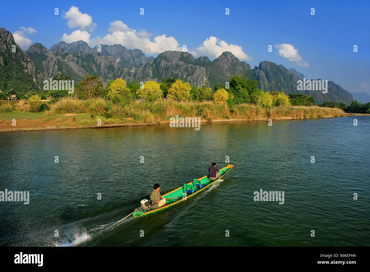 Motorboat moving on Nam Song River in Vang Vieng, Laos. Vang Vieng is a popular destination for adventure tourism in a limestone karst landscape. Stock Photo