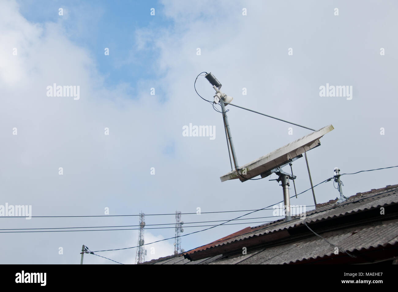 Modern high technology satellite on a roof with cloudy sky Stock Photo